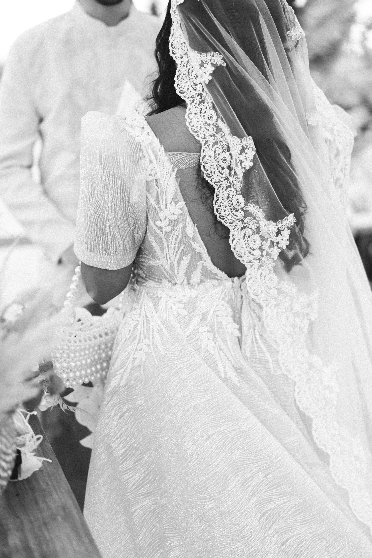 Close-up details of delicate white lace and beading on a wedding veil during outdoor ceremony near Porto Portugal