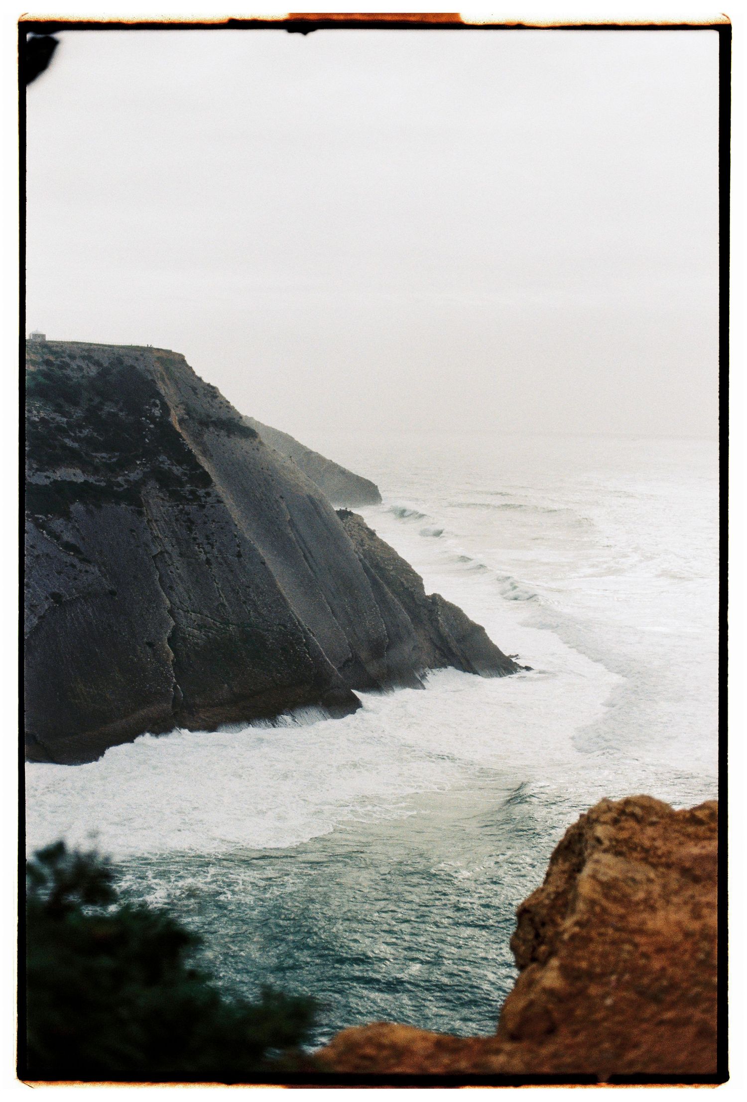 A film photograph of the dramatic Atlantic coastline with rocky cliffs and waves, Portugal