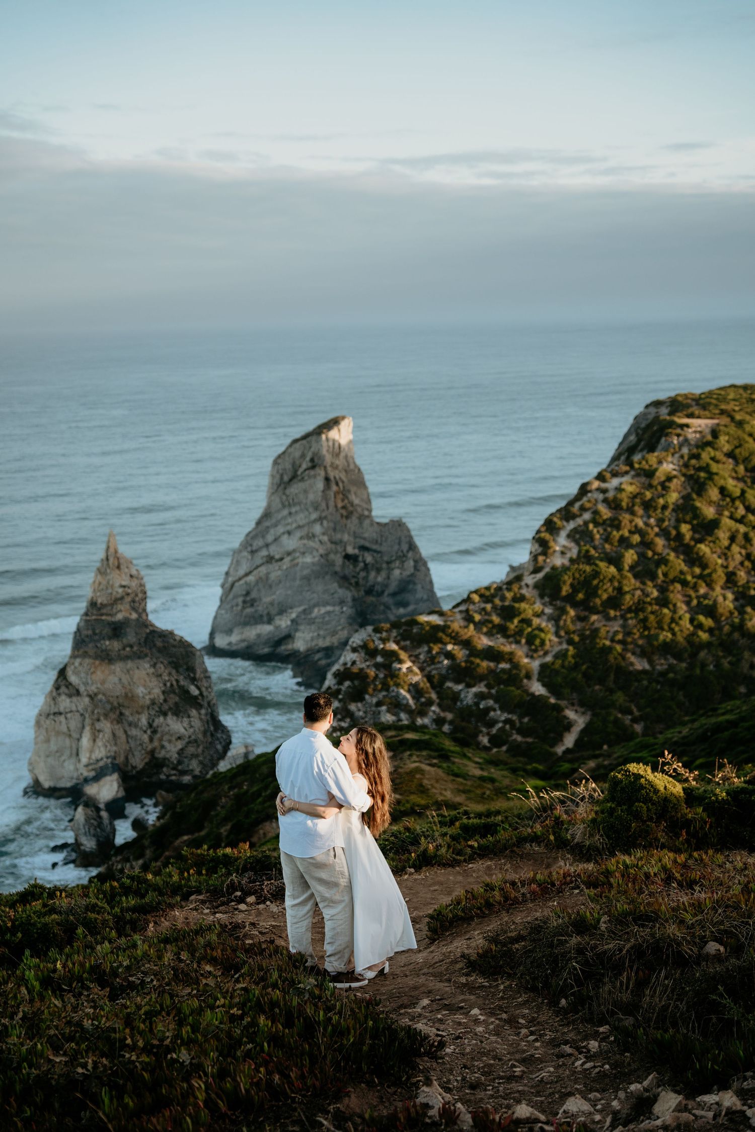 A couple standing together on the coastal cliffs above the Atlantic ocean during an elopement in Portugal