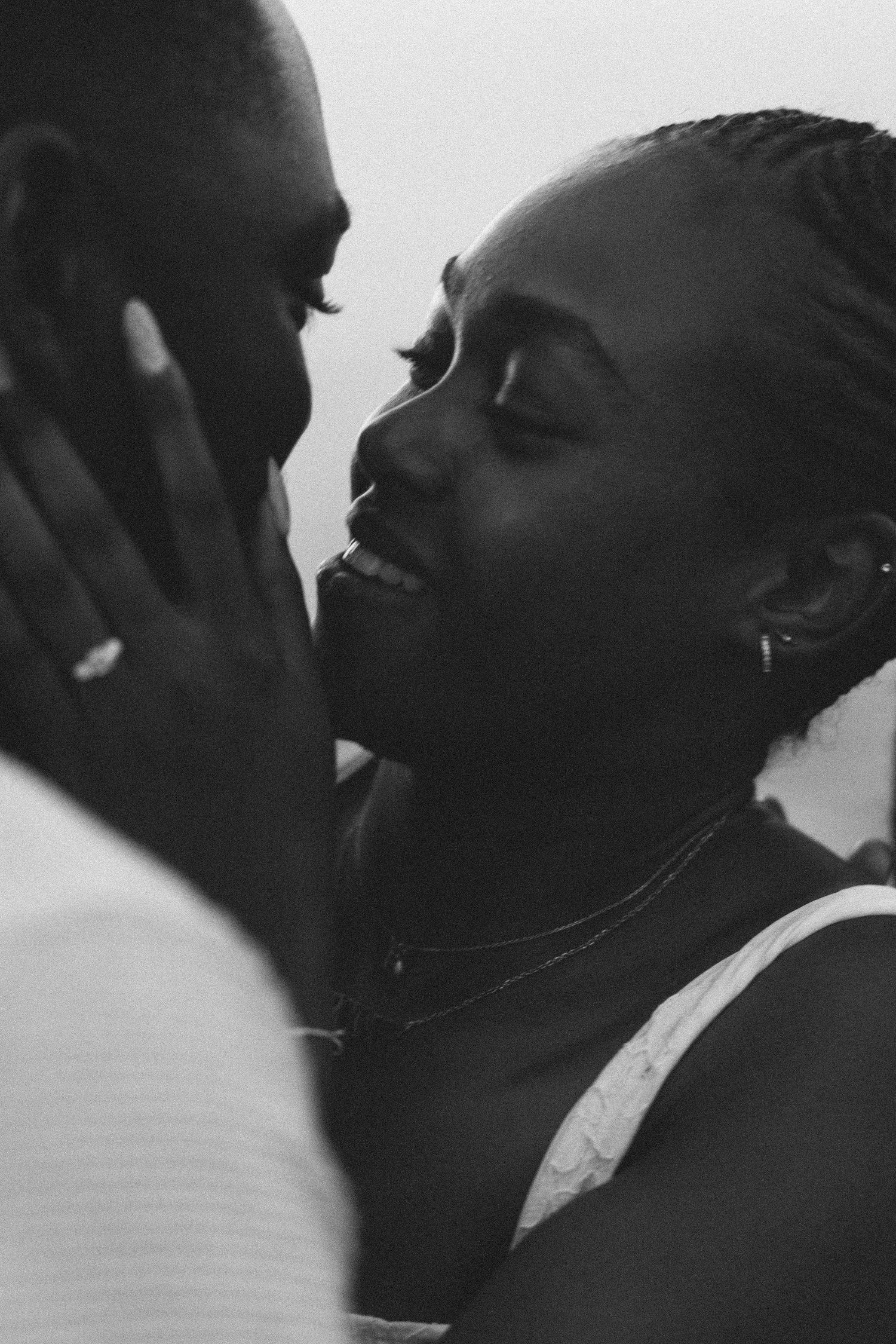 A close-up black and white photograph of a couple sharing a kiss during a couples session in Portugal