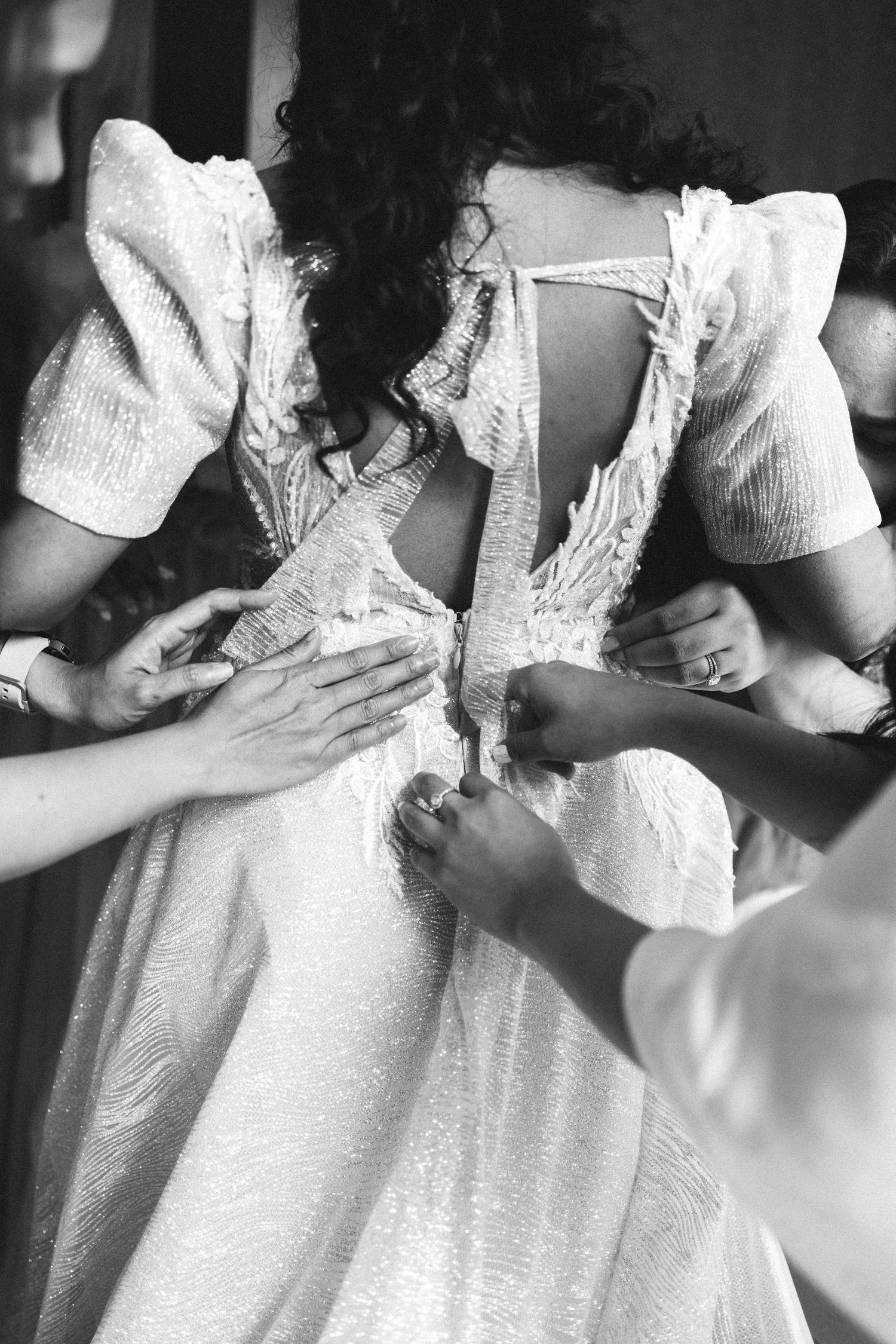 Hands fastening bride's wedding dress during getting ready, documentary wedding photography Portugal