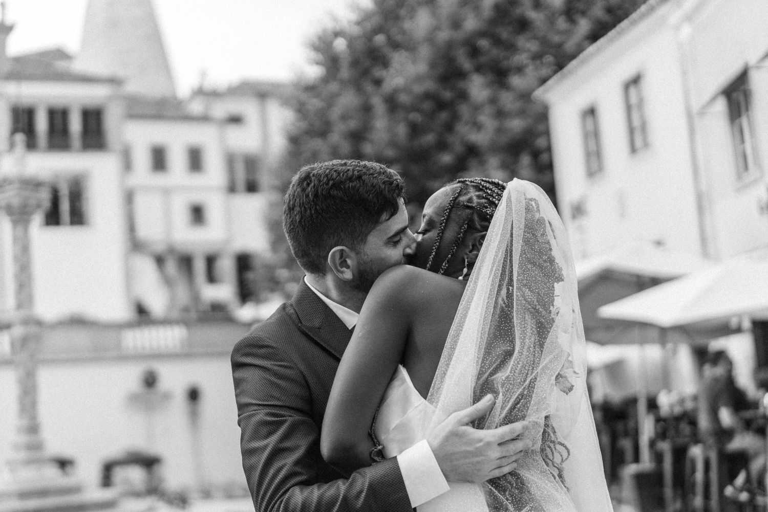 A couple sharing a tender moment with a Sintra cityscape behind them during their wedding in Portugal