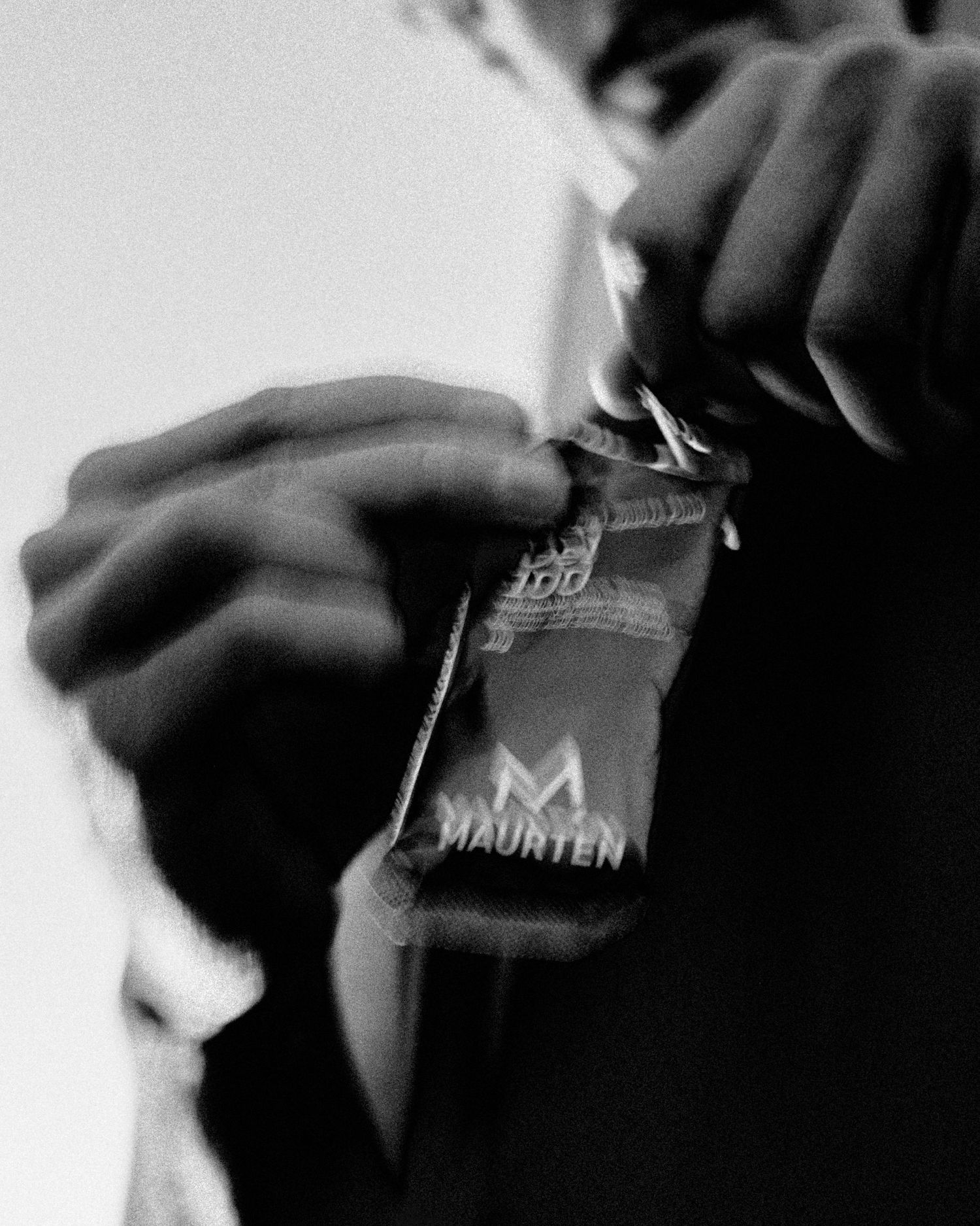 Close-up black and white shot of hands holding a branded product card.