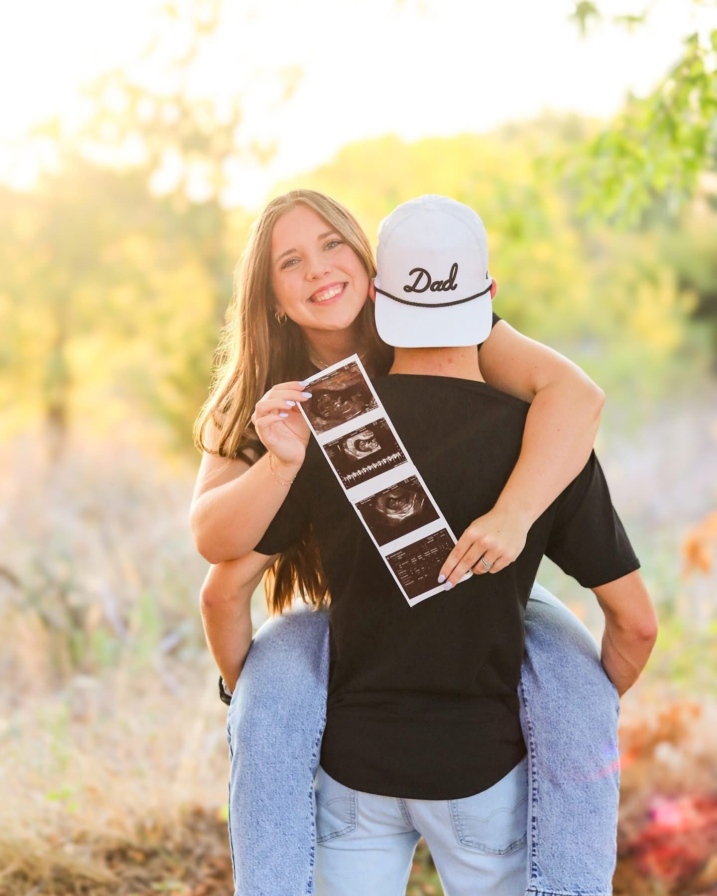 Expecting couple holding ultrasound pictures.