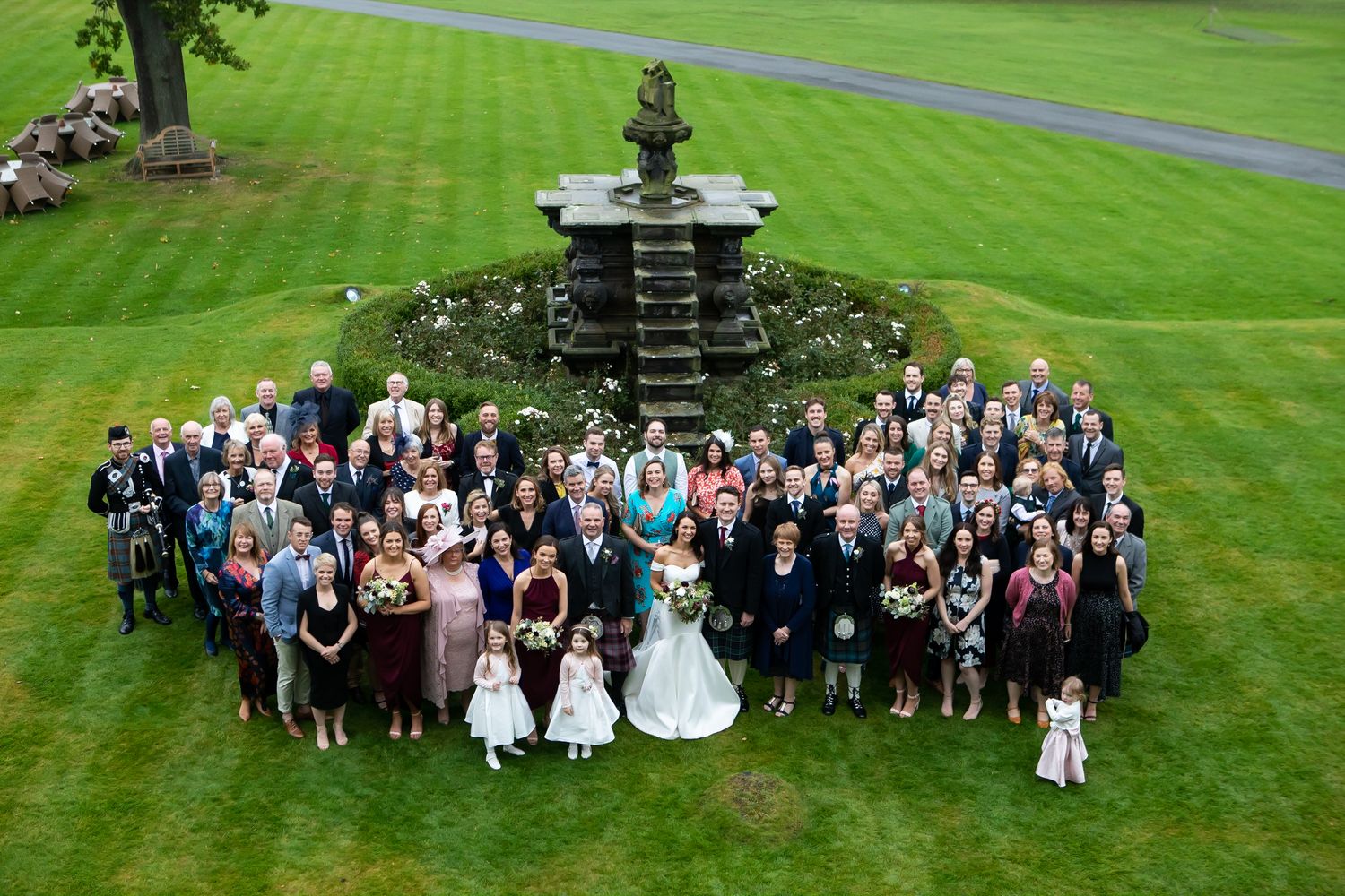 Large outdoor group wedding photo captured from a high angle view
