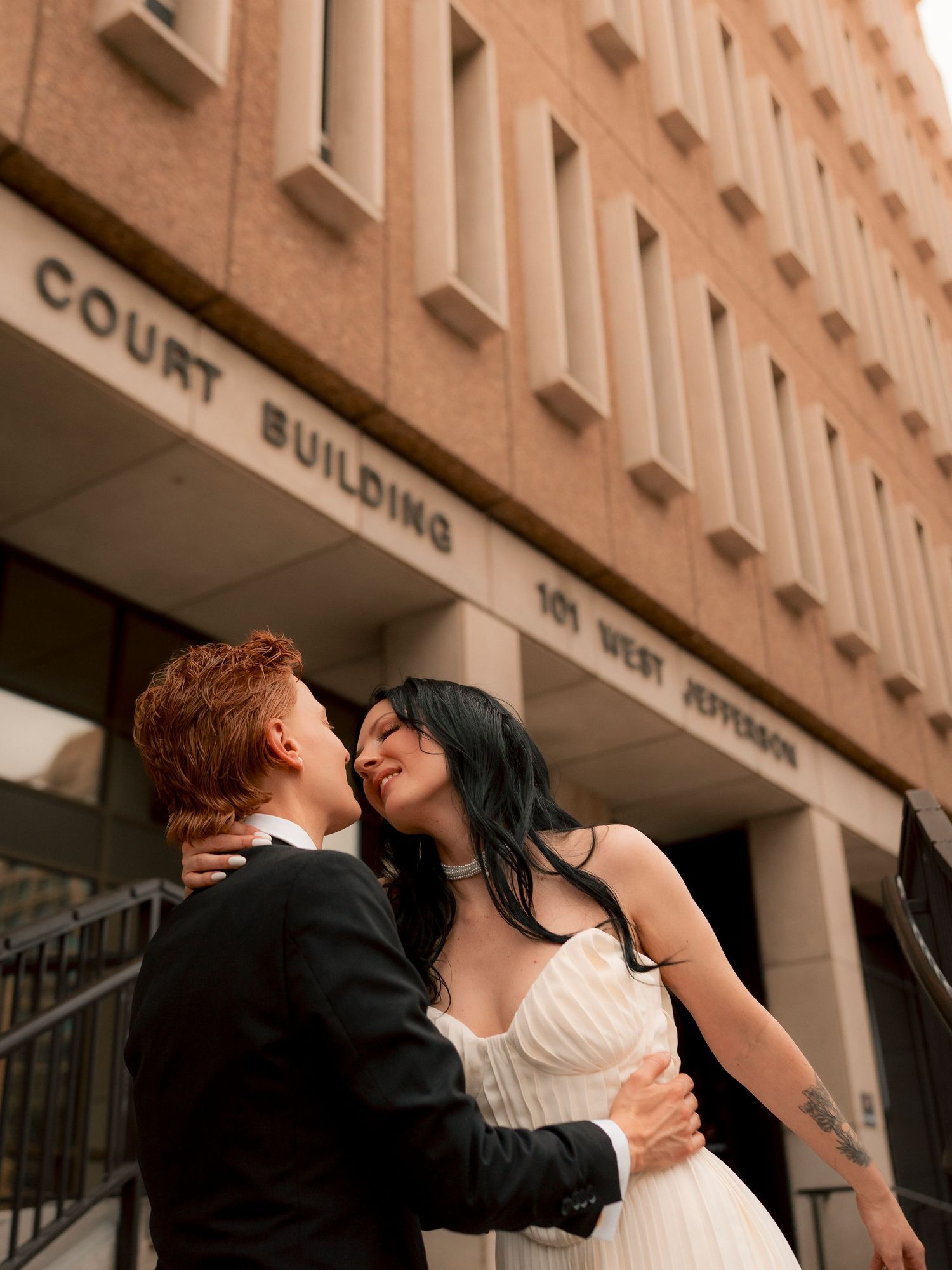 Couple embraces and smiles outside the Court Building at 101 West Jefferson.