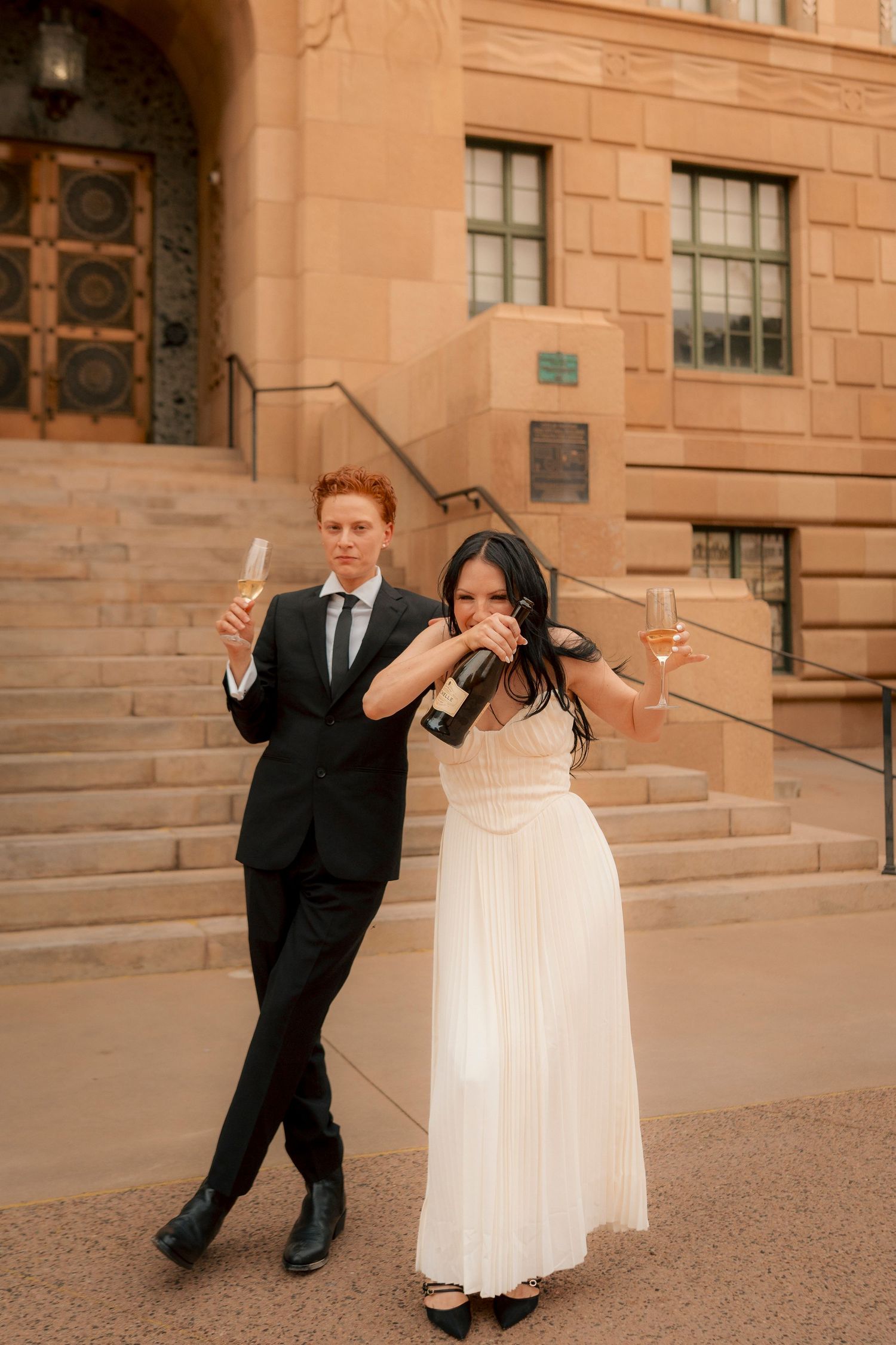 Newlyweds pour and drink champagne outside Phoenix City Hall after their ceremony.