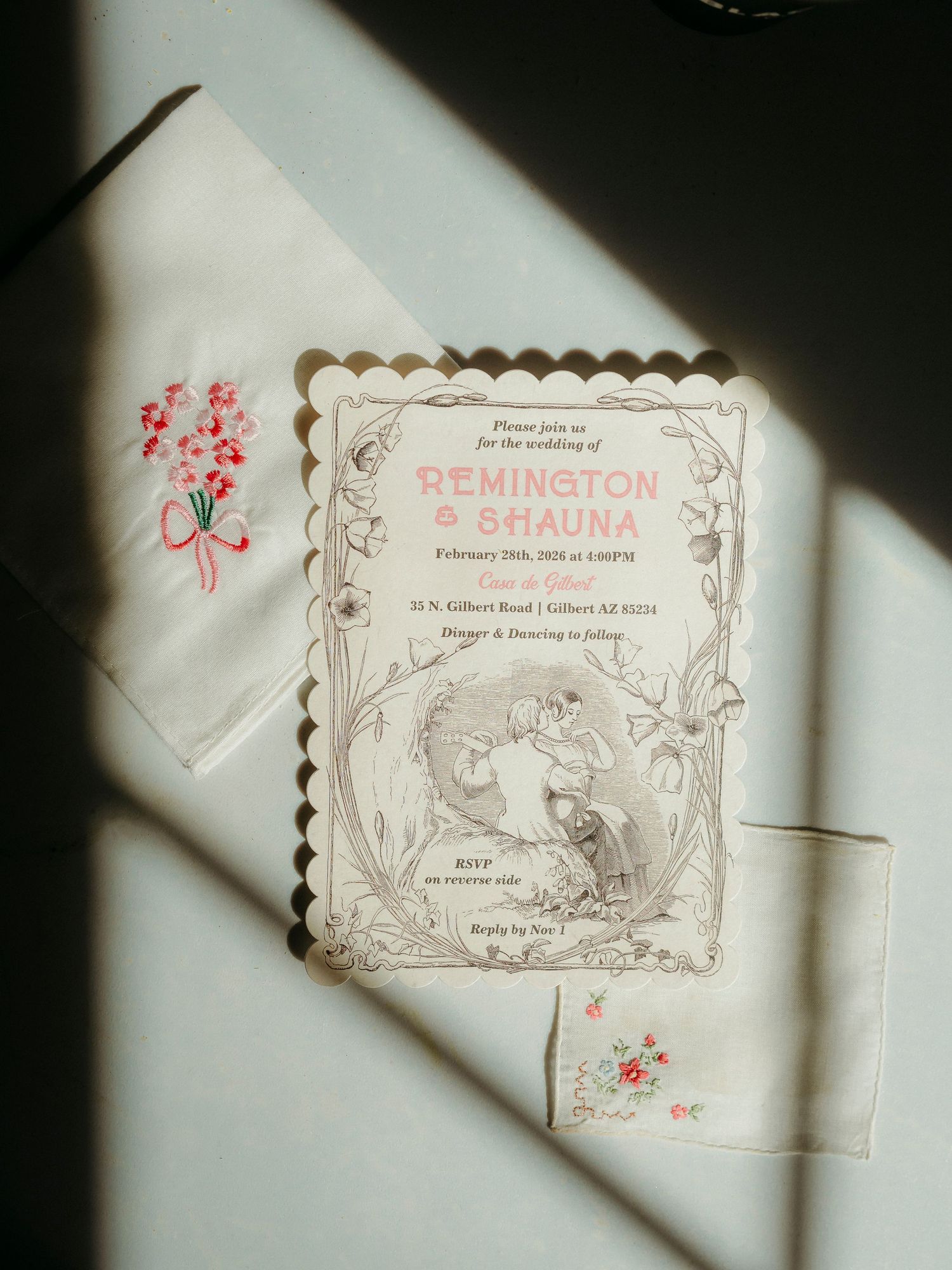 Elegant wedding invitation for Remington and Shauna displayed on embroidered handkerchiefs with floral details.