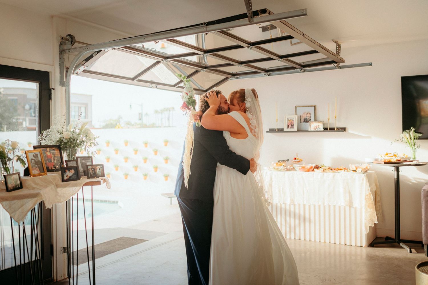 Bride and groom share a tender first dance embrace inside a decorated garage wedding venue.