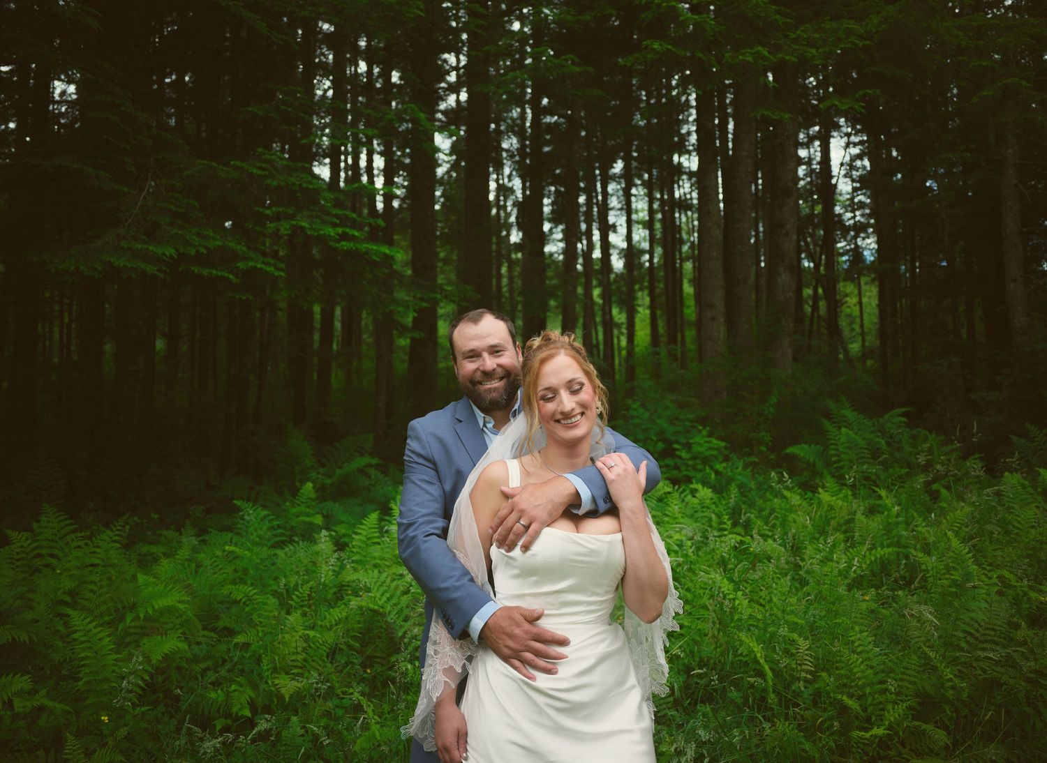 A photo of a newly married couple embracing each other near a Washington State forest. Photo by N&D Wedding Photography and Film