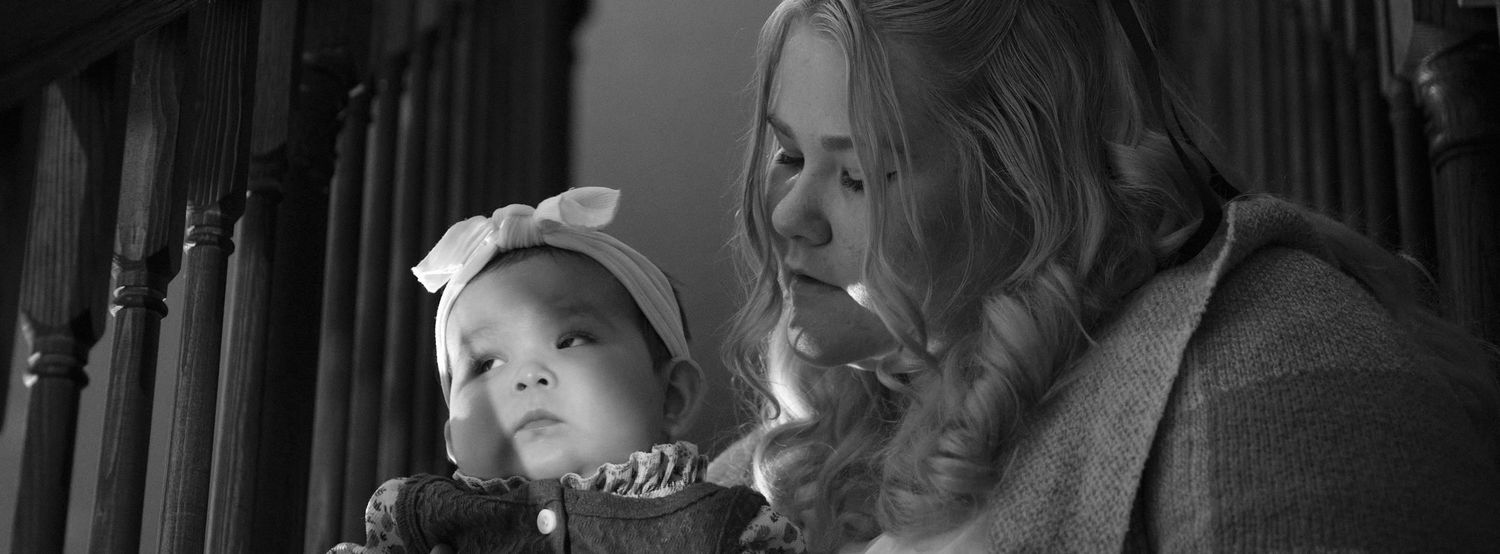 A baby and her mother sitting on the stairs, taken in Snohomish County, Washington State. Photo by N&D Wedding Photography and Film