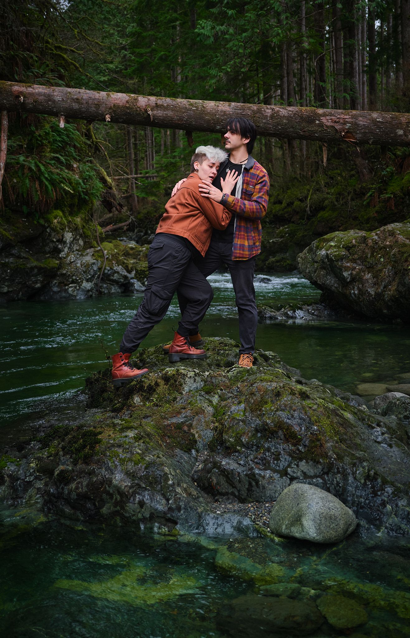 A couple acting silly while on the river in forest in Washington State. Photo by N&D Wedding Photography and Film