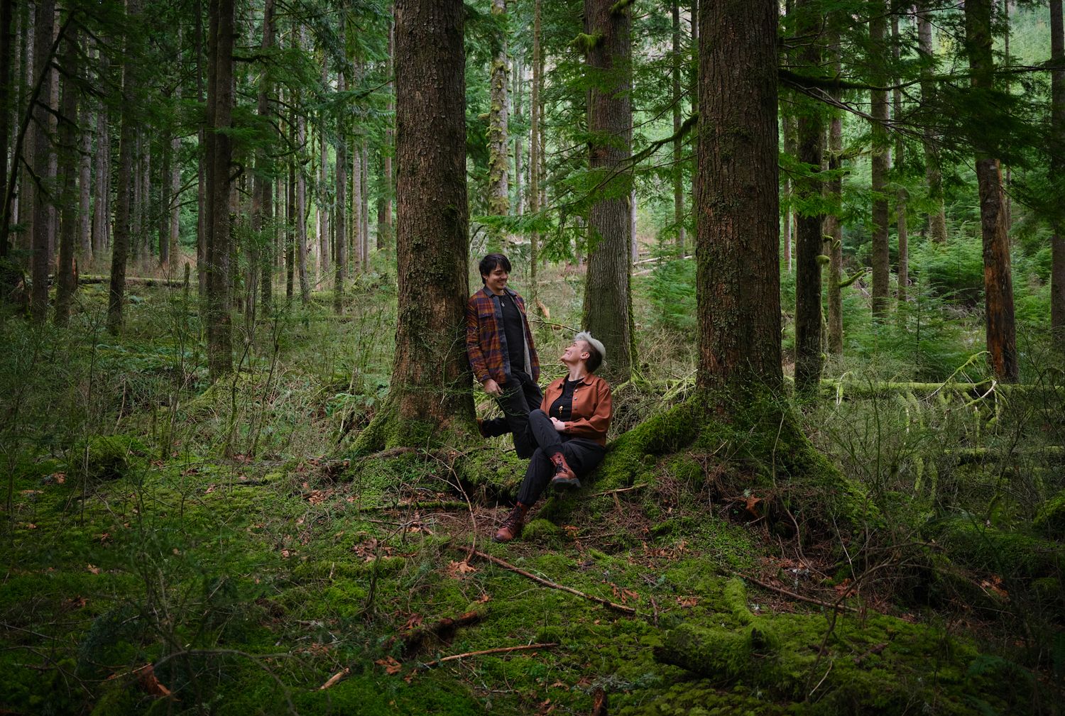 A couple leisurely hanging out in forest in Washington State. Photo by N&D Wedding Photography and Film