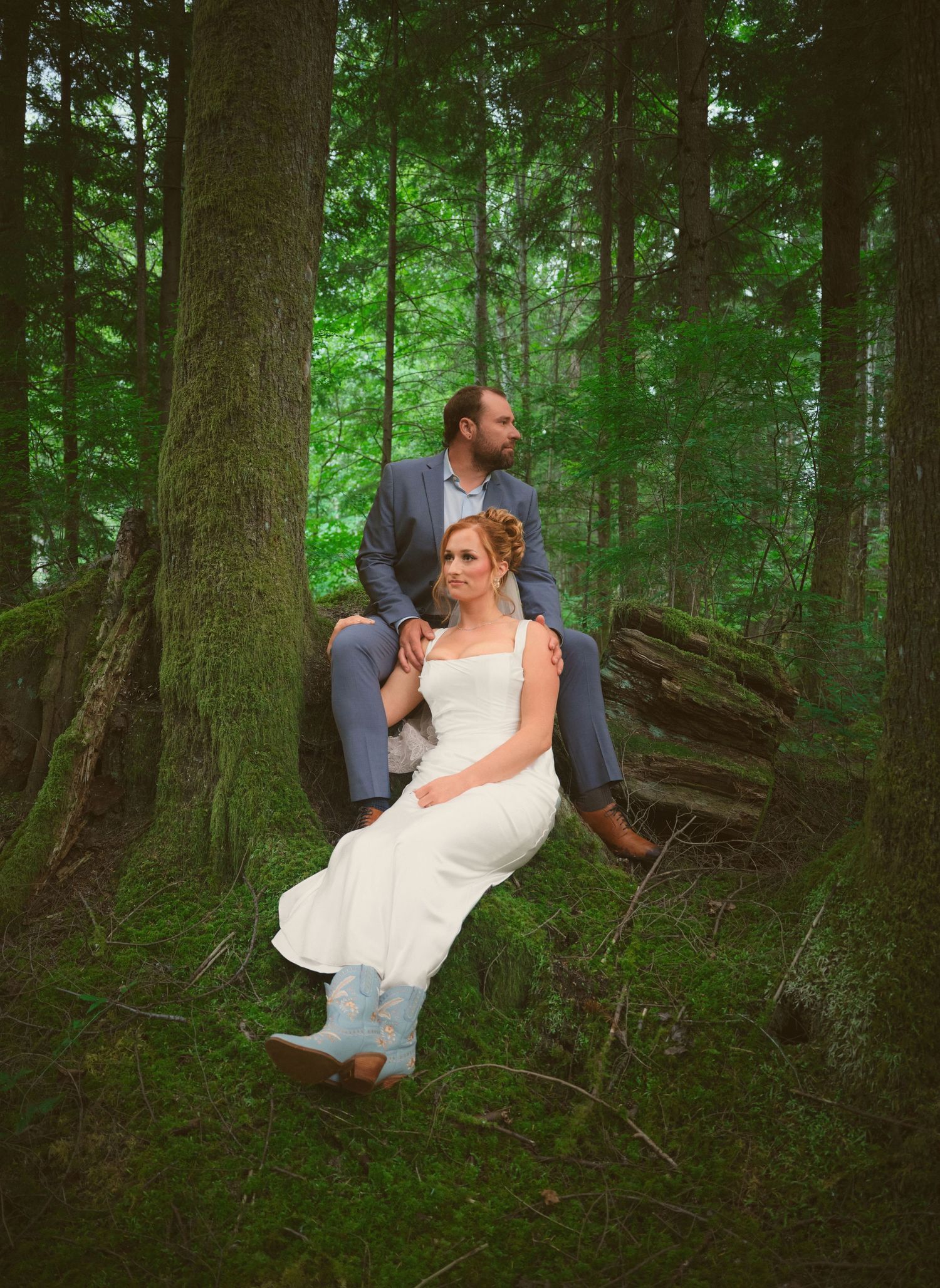 A photo in a Washington State forest of a newly married couple sitting amongst the trees . Photo by N&D Wedding Photography and Film