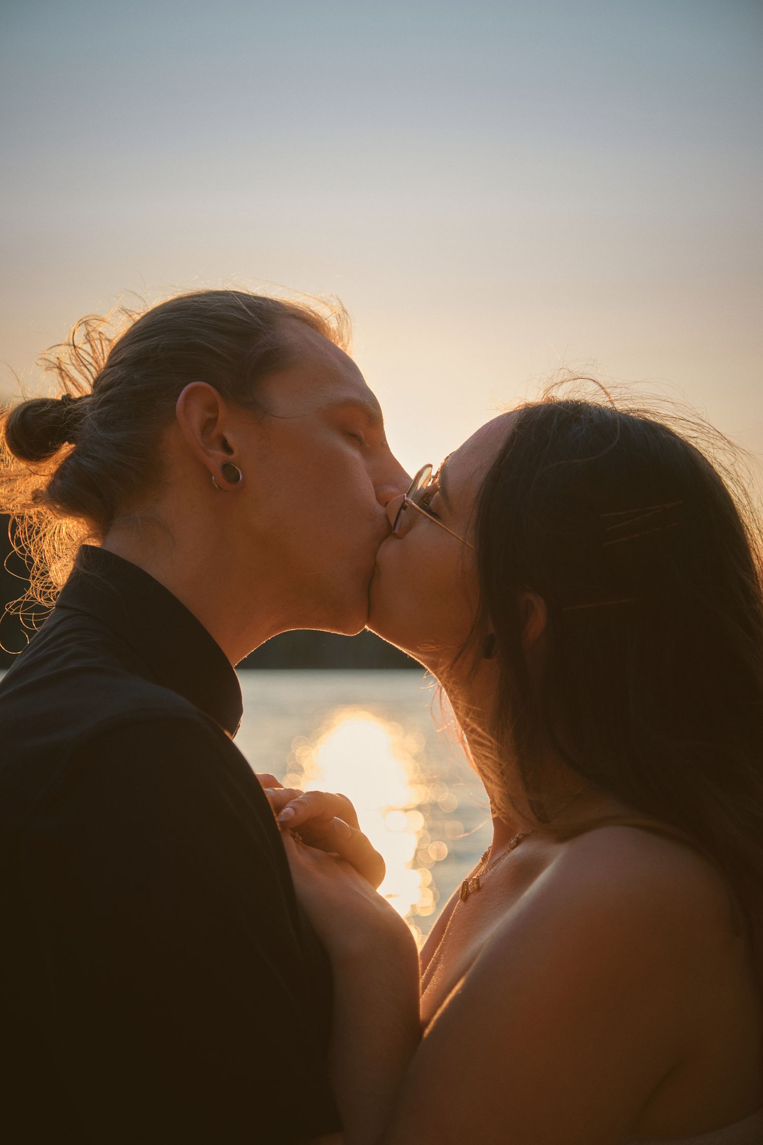 An engaged couple shares a kiss in front of Spada Lake in Snohomish County Washington. Photo by N&D Wedding Photography and Film