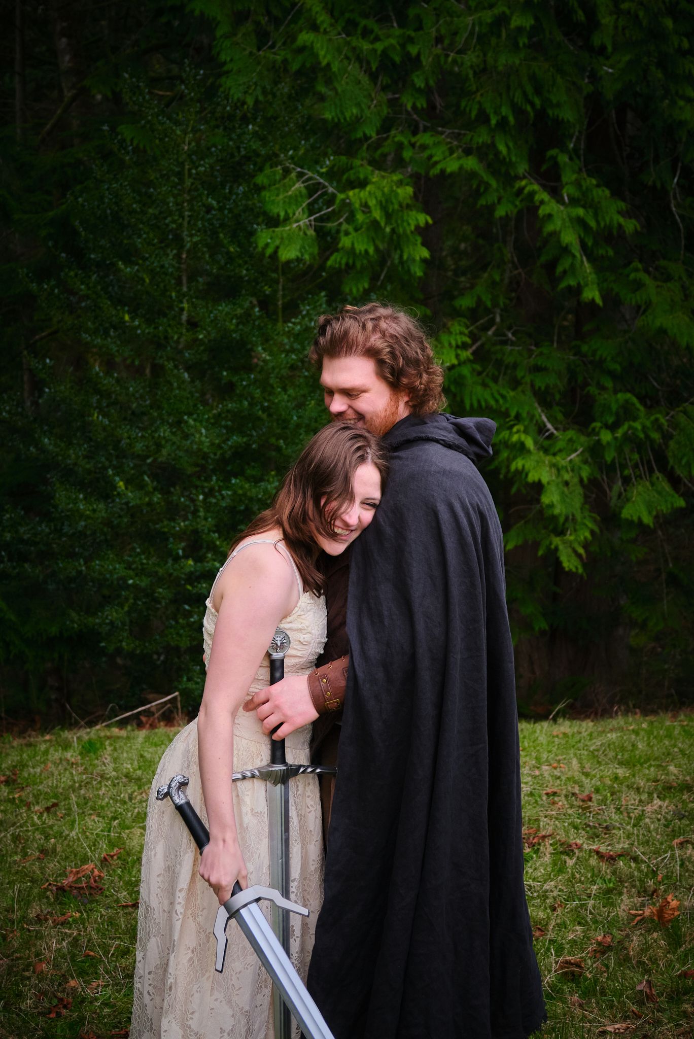 A couple holding swords and laughing while embracing each other, taken in WA, State. Photo by N&D Wedding Photography and Film