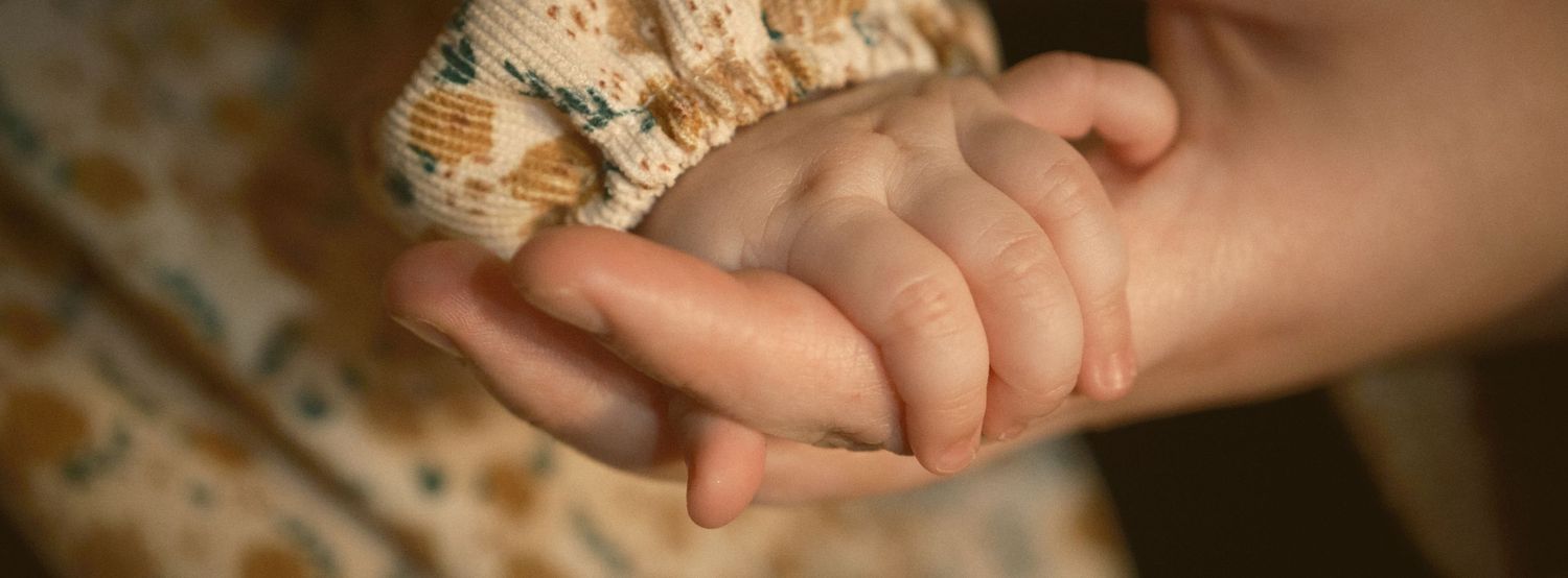 This is an image of a baby holding her mother's hand, taken in Snohomish County, Washington State. Photo by N&D Wedding Photography and Film