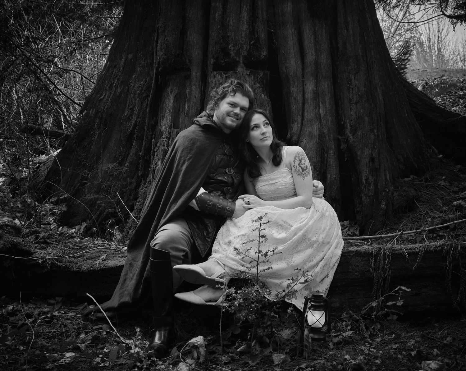A couple sitting near an old tree embracing each other, taken in Washington State. Photo by N&D Wedding Photography and Film