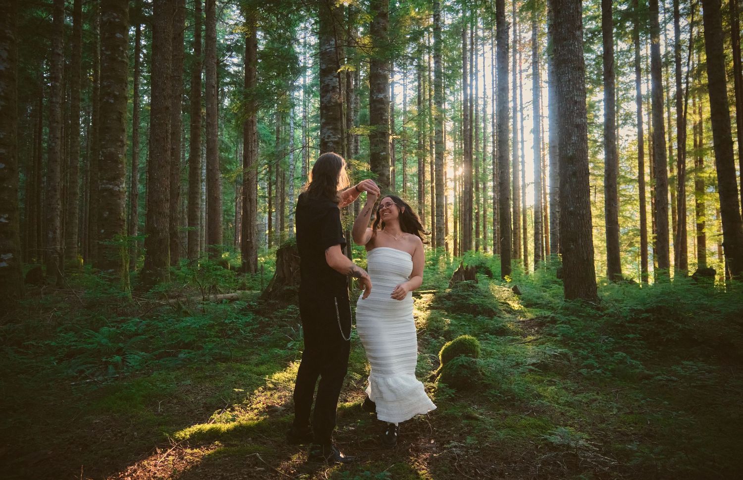 An engaged couple dancing in a forest in Washington State. Photo by N&D Wedding Photography and Film