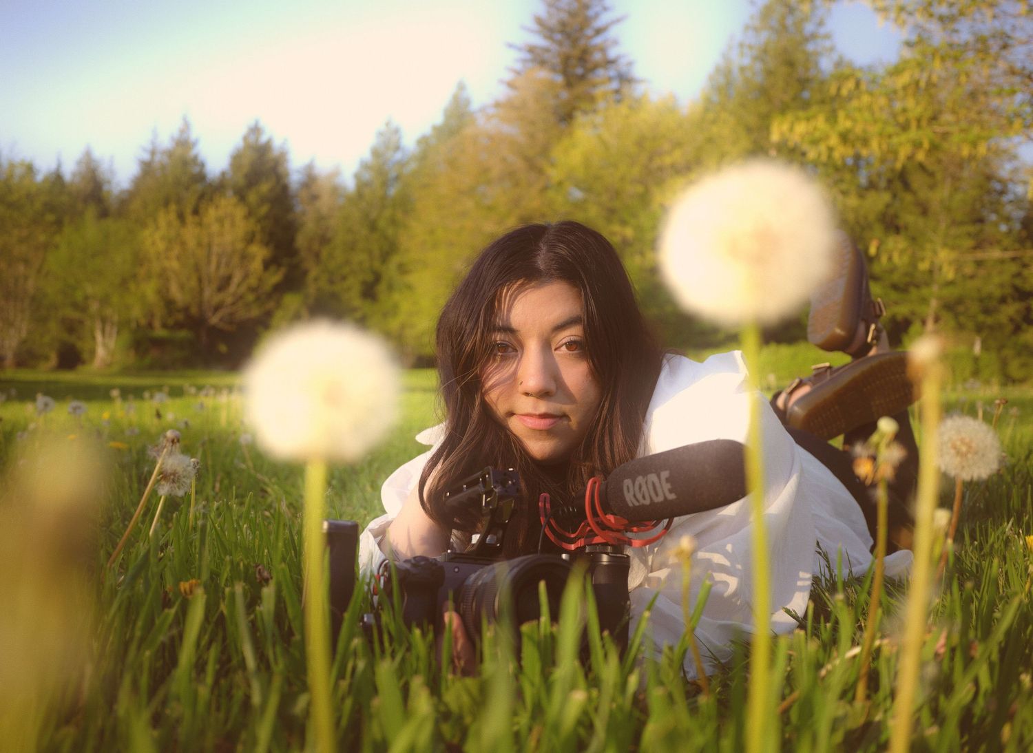 Nicole the videographer for N&D Wedding Photography and Film holding her FX30 cinema camera in a grove in Washington State.