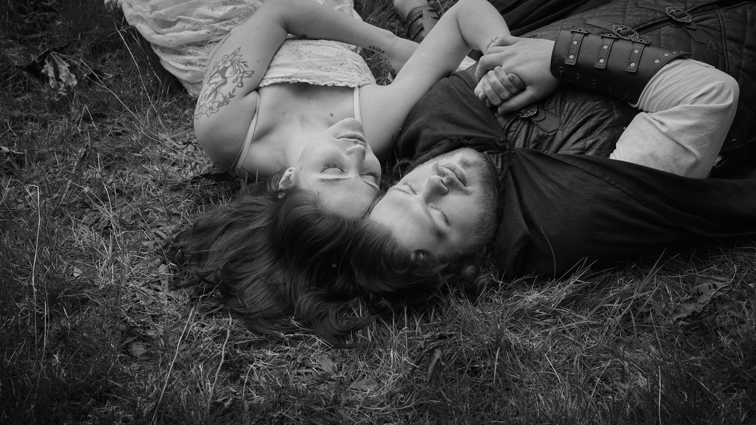 A couple laying down in a field their heads are touching, taken in WA, State. Photo by N&D Wedding Photography and Film