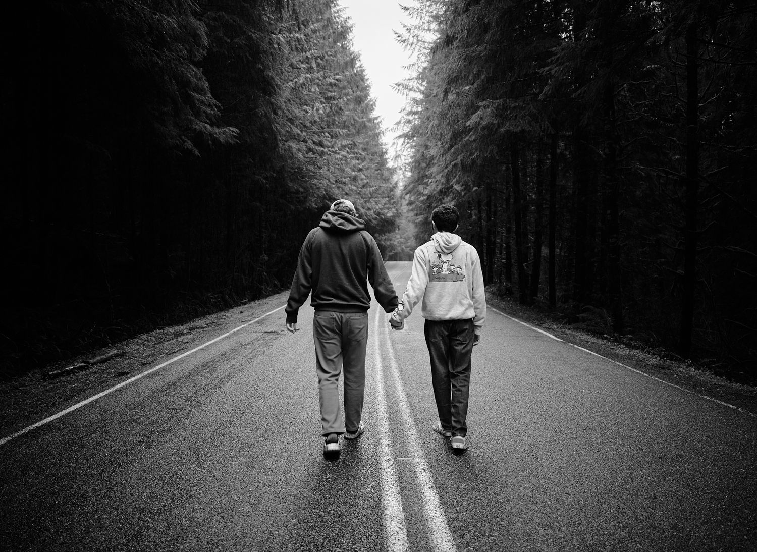 A couple walking down a rural road in a WA, State forest in the rain. Photo by N&D Wedding Photography and Film