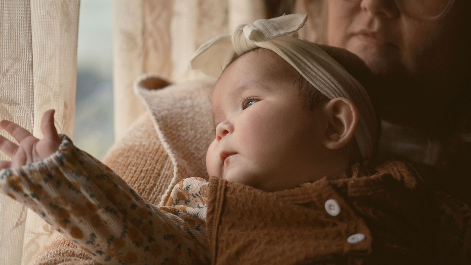A baby trying to look out the window, taken in Snohomish County, Washington State. Photo by N&D Wedding Photography and Film