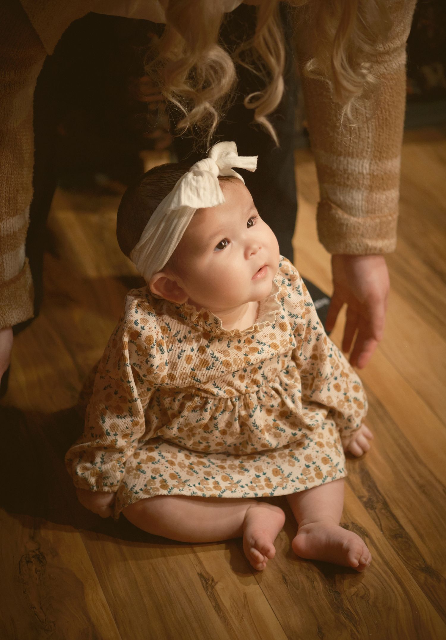 A baby sitting on the floor and looking inquisitive, taken in Snohomish County, Washington State. Photo by N&D Wedding Photography and Film