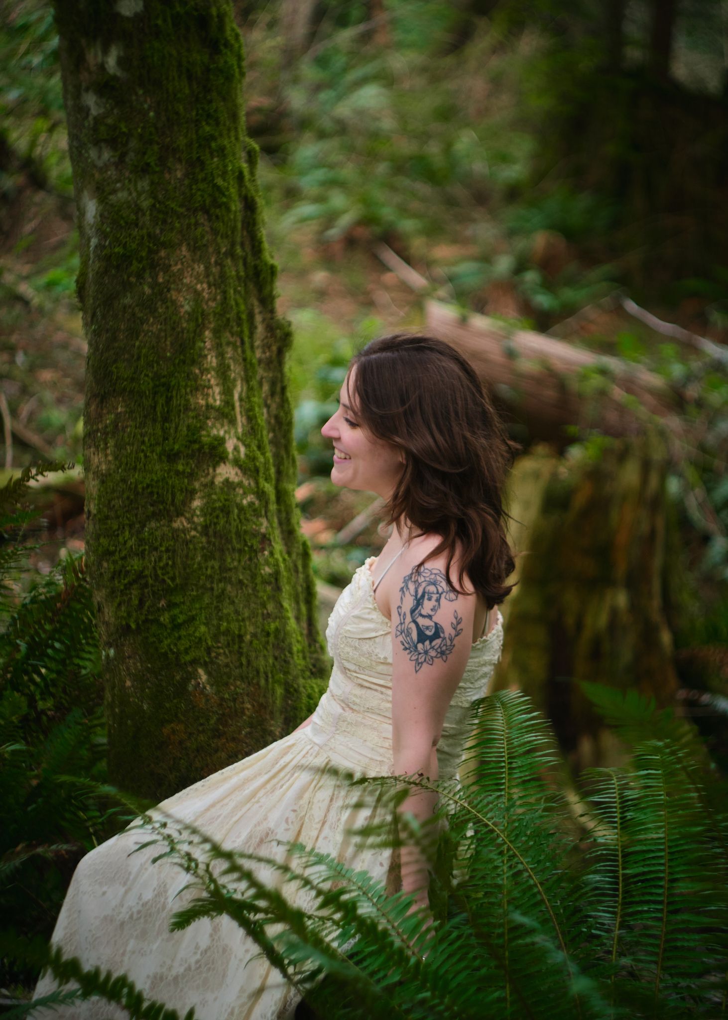 A woman laughing and smiling with joy in a forest in Washington State. Photo by N&D Wedding Photography and Film