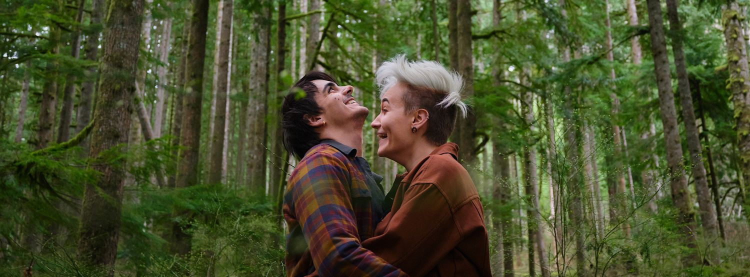 A couple embracing and laughing while in forest in Washington State. Photo by N&D Wedding Photography and Film