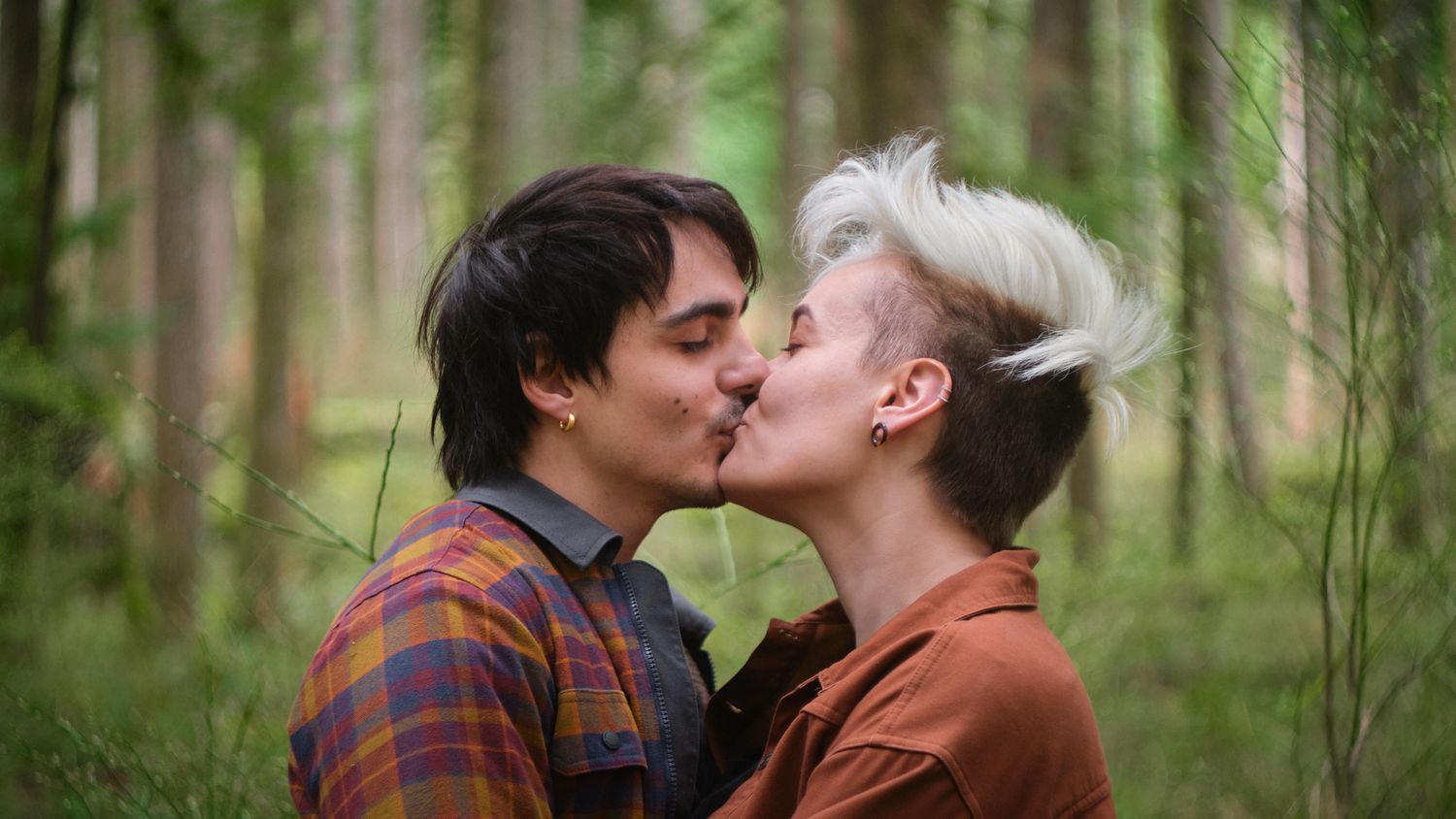 A couple kissing and embracing in a dense forest in Washington State. Photo by N&D Wedding Photography and Film