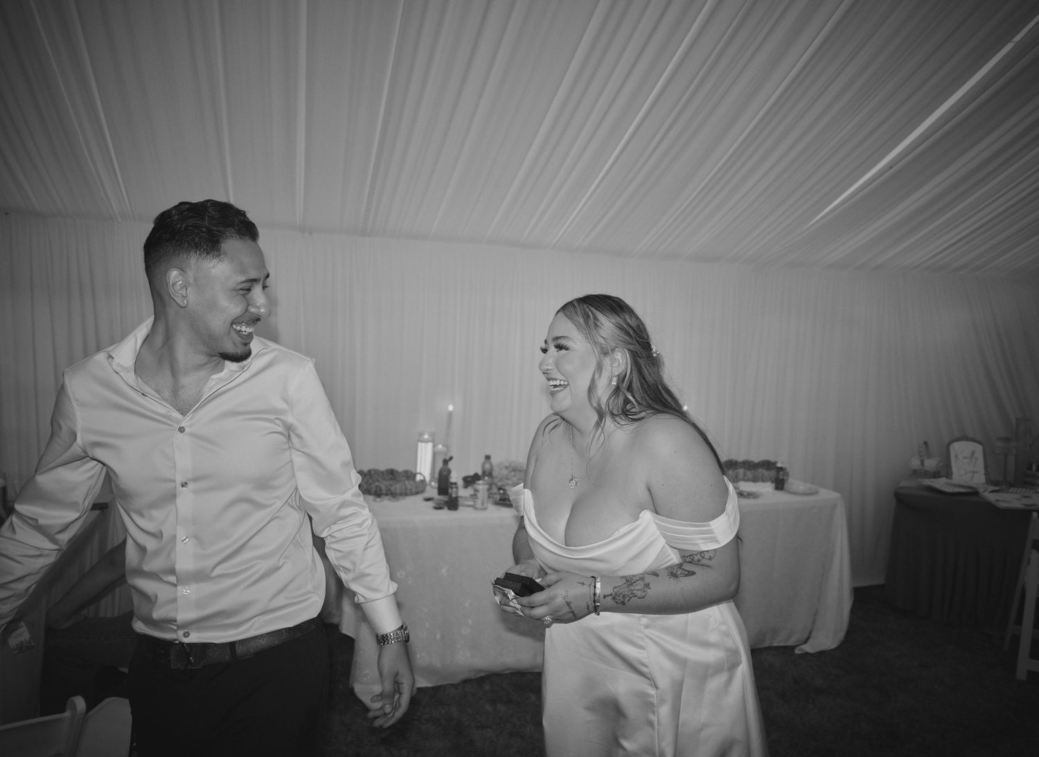 A bride laughing with her friend during the reception in Tulalip Washington. Photo by N&D Wedding Photography and Film