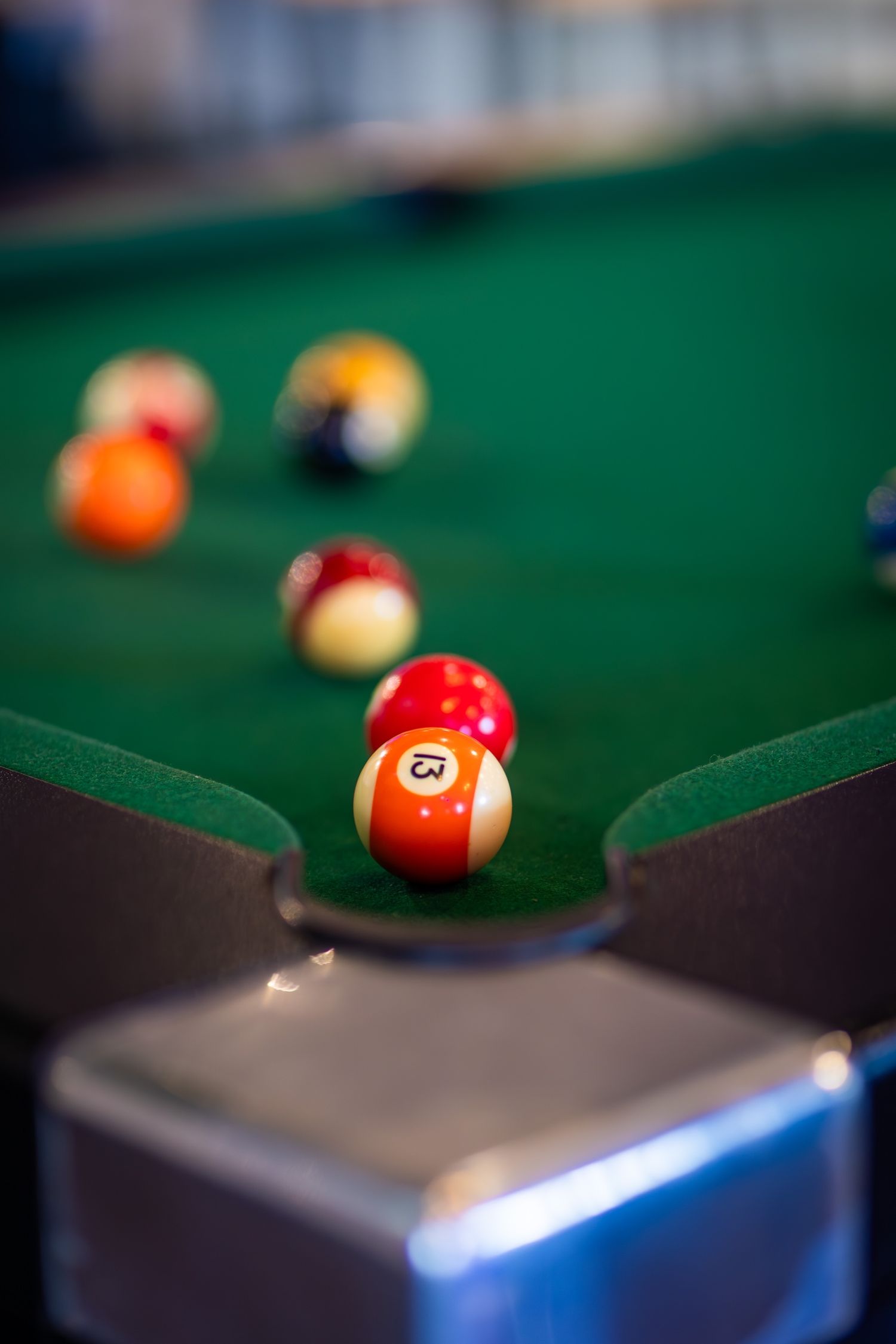 Pool balls scattered on green felt billiards table with selective focus.