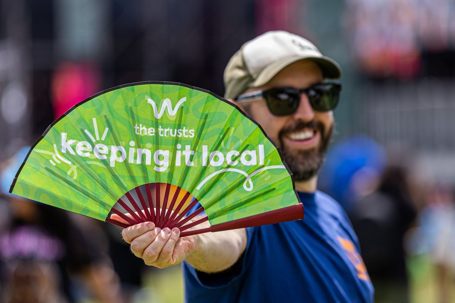 Colorful promotional hand fans displayed at an outdoor event booth.