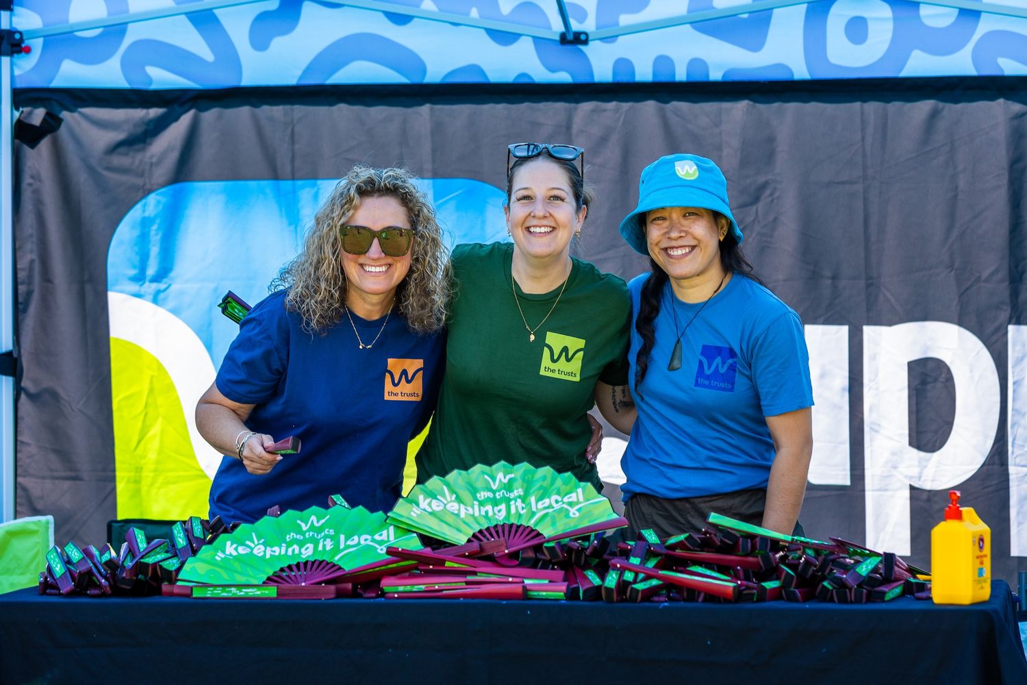 Event staff in coordinated uniforms working at outdoor promotional booth.