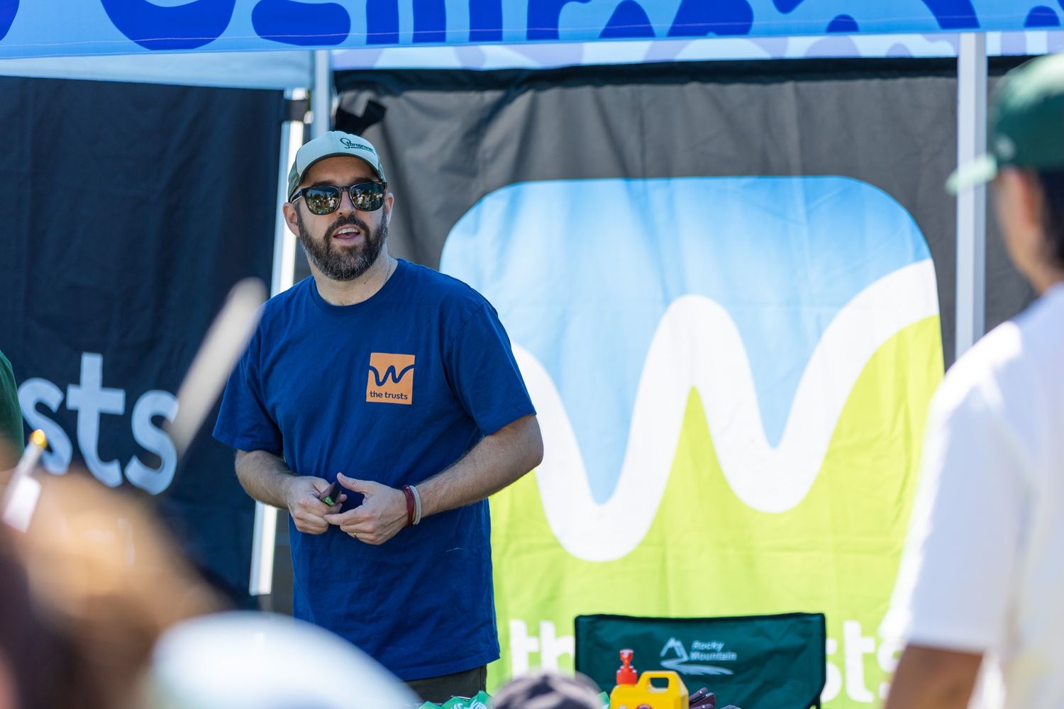 Event workers in blue and green uniforms managing a branded display booth.
