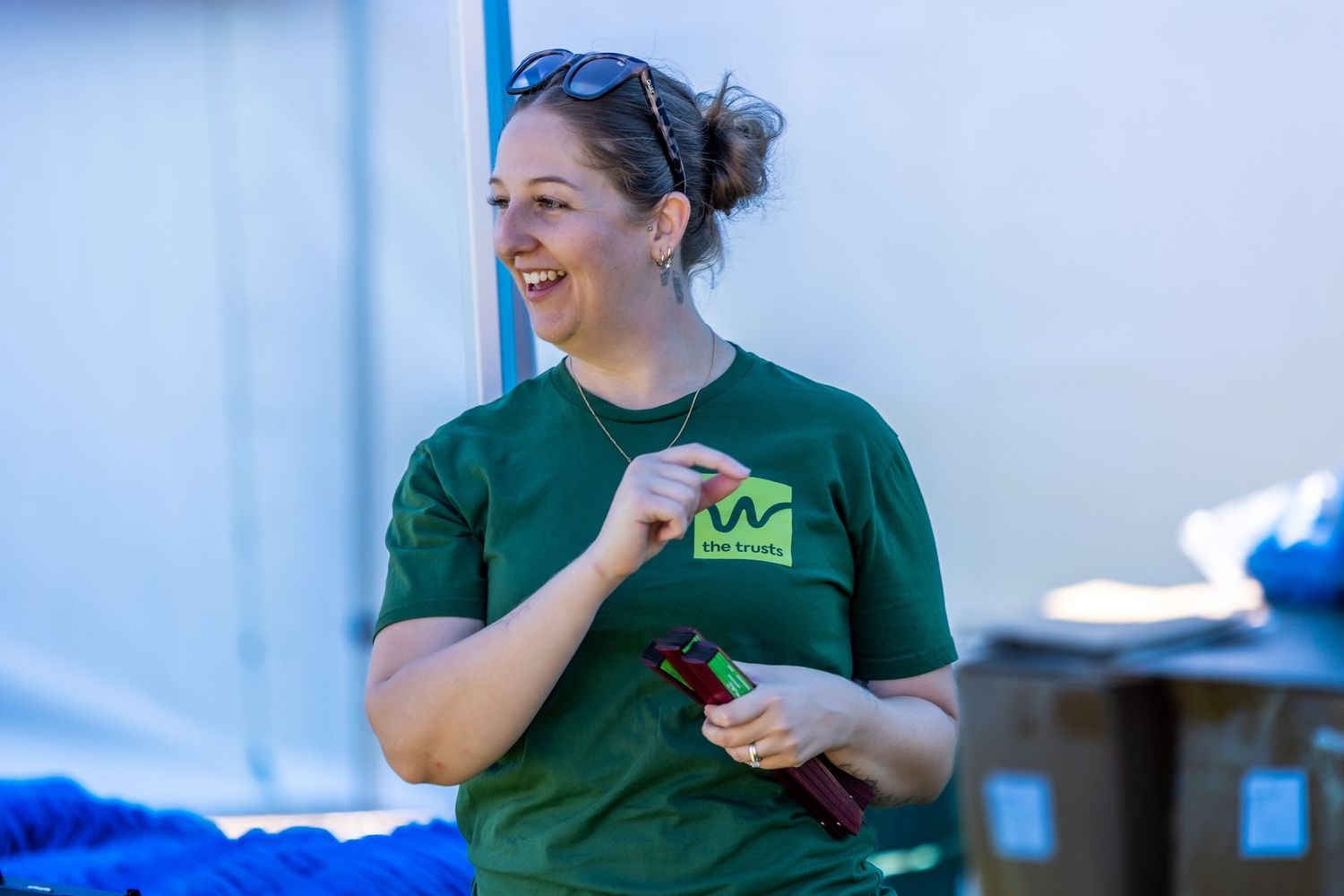 Event staff in green shirts working behind a display table.