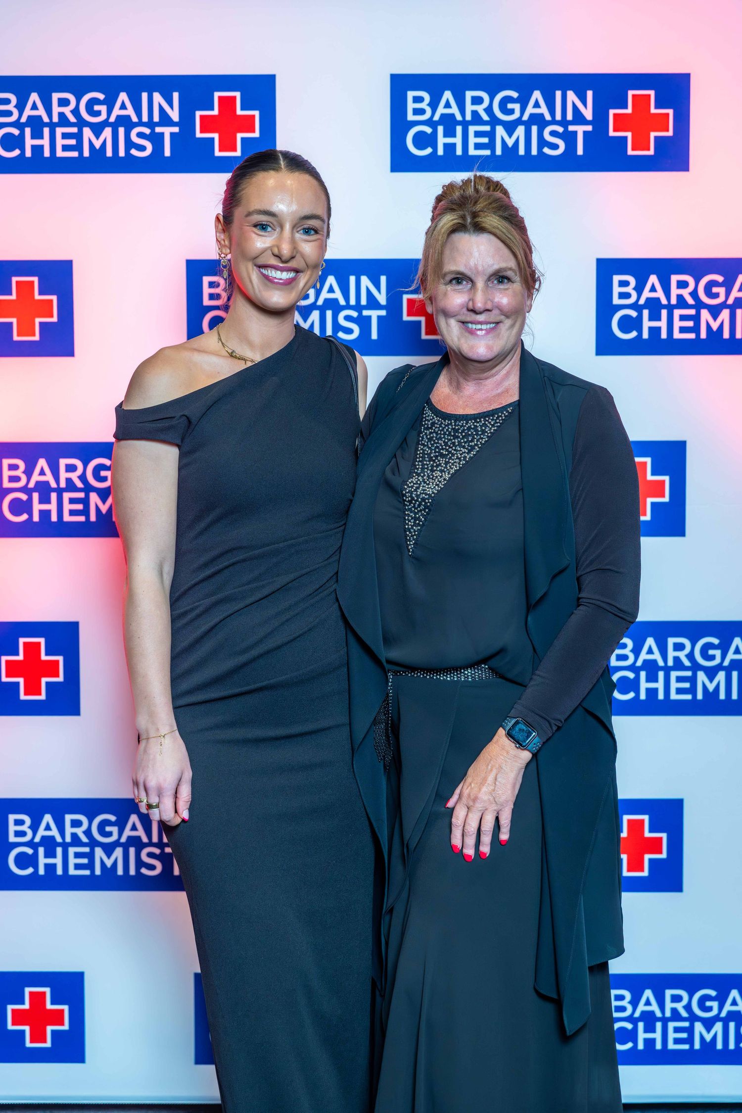 Corporate event backdrop with Bargain Chemist branding and logo display.