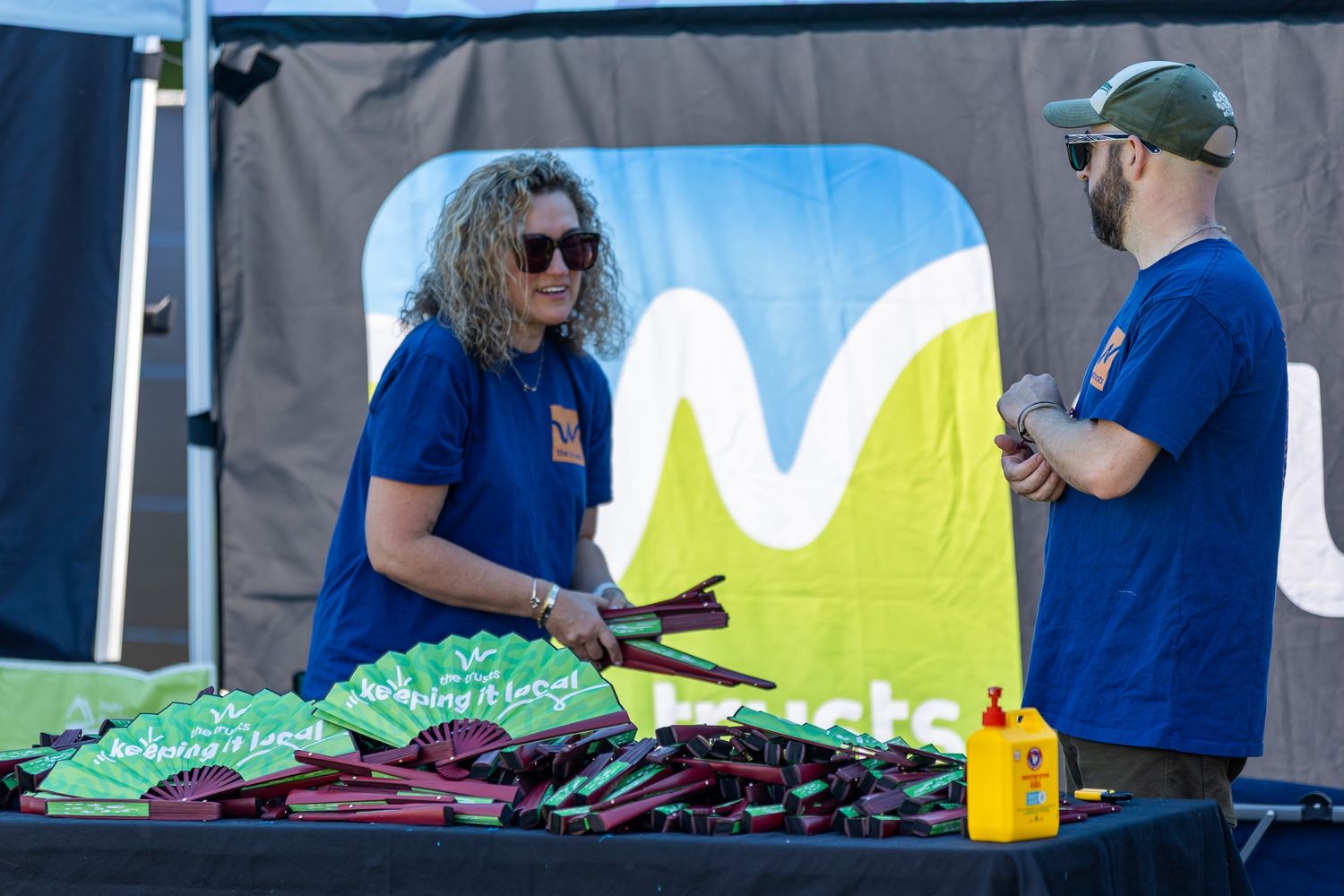 Event setup with dark backdrop and staff members working behind tables.