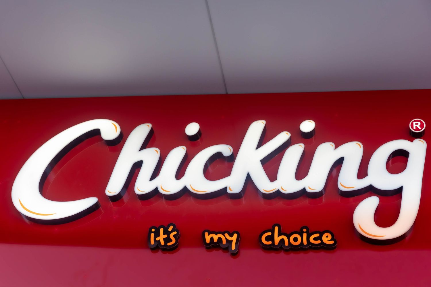 Chicking fast food restaurant red illuminated sign with white lettering and tagline its my choice.