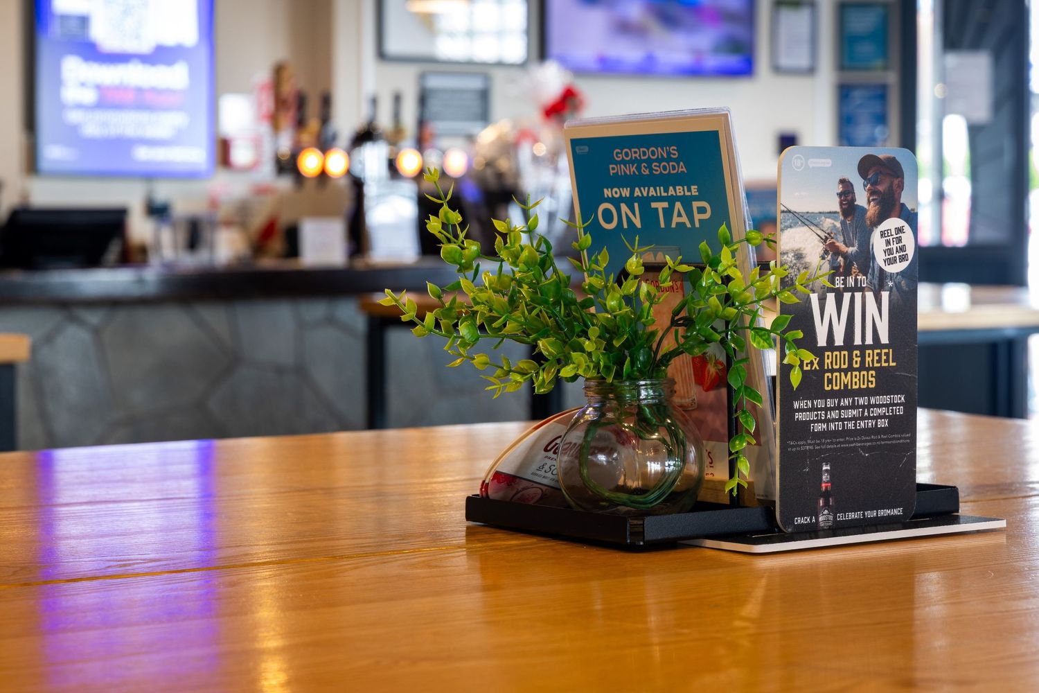 Bar counter with menu cards and table settings in warm lighting.