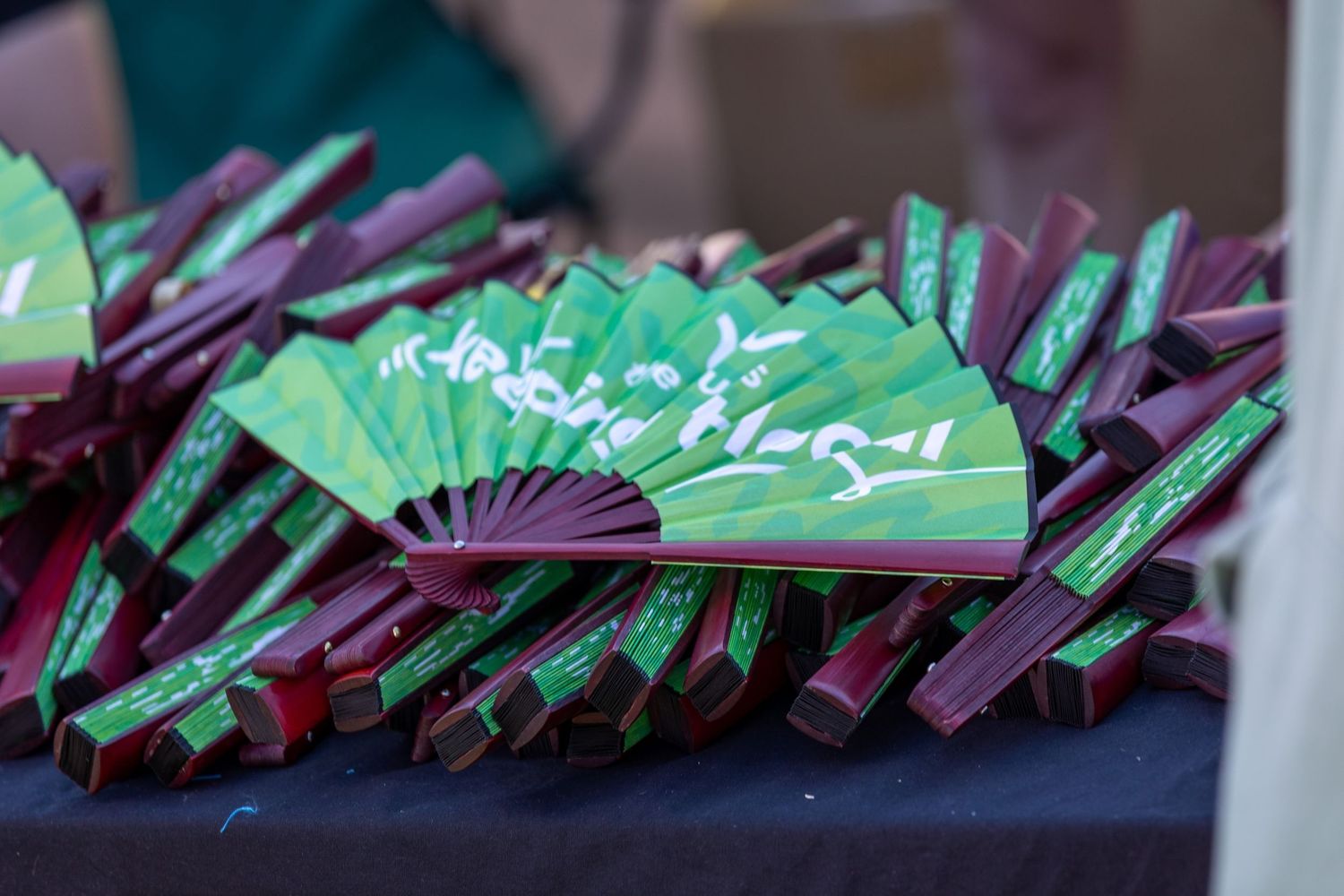 Row of folded promotional materials or lanyards arranged on a dark surface.