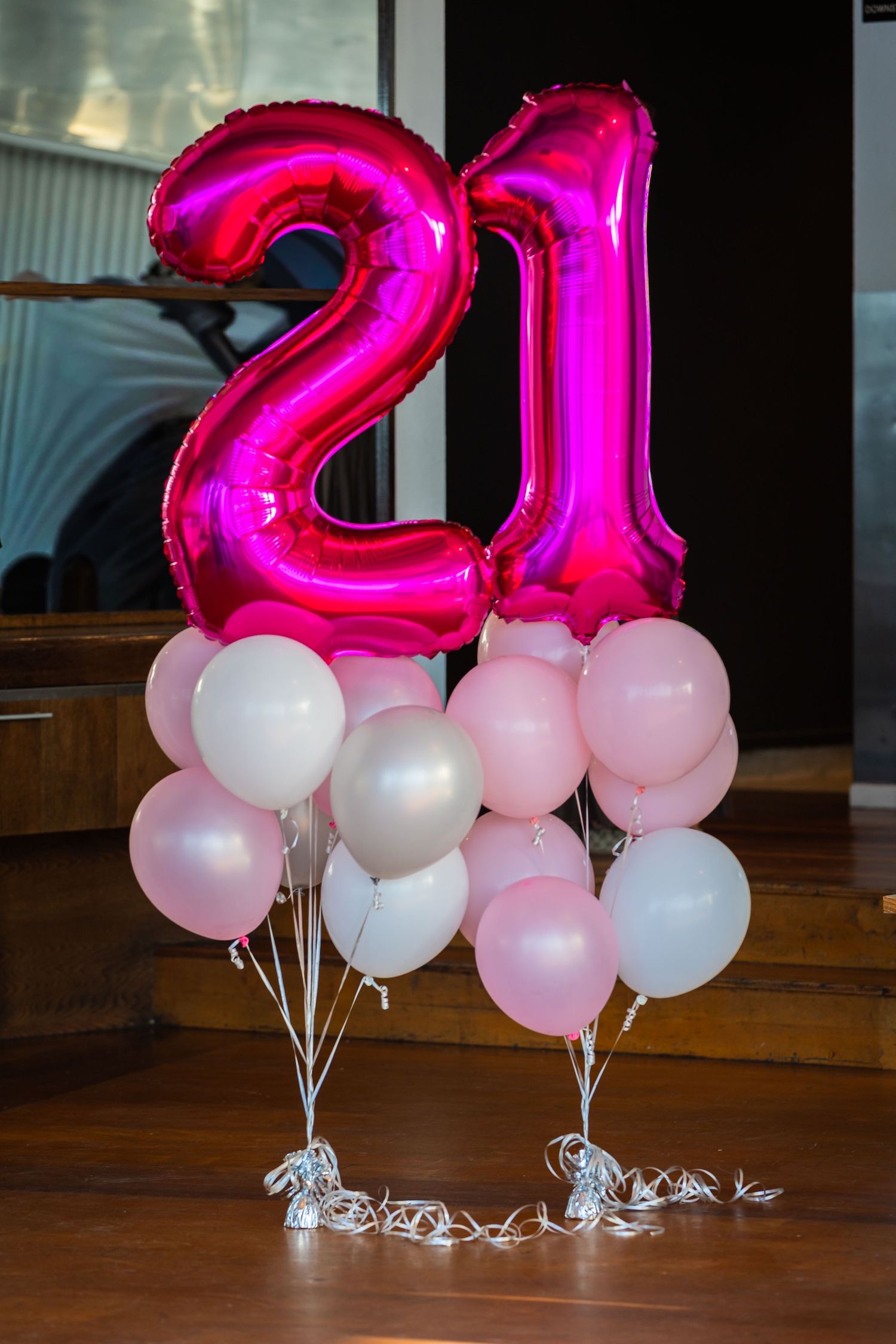 Pink and white balloons with large pink number 21 foil balloons for birthday party.