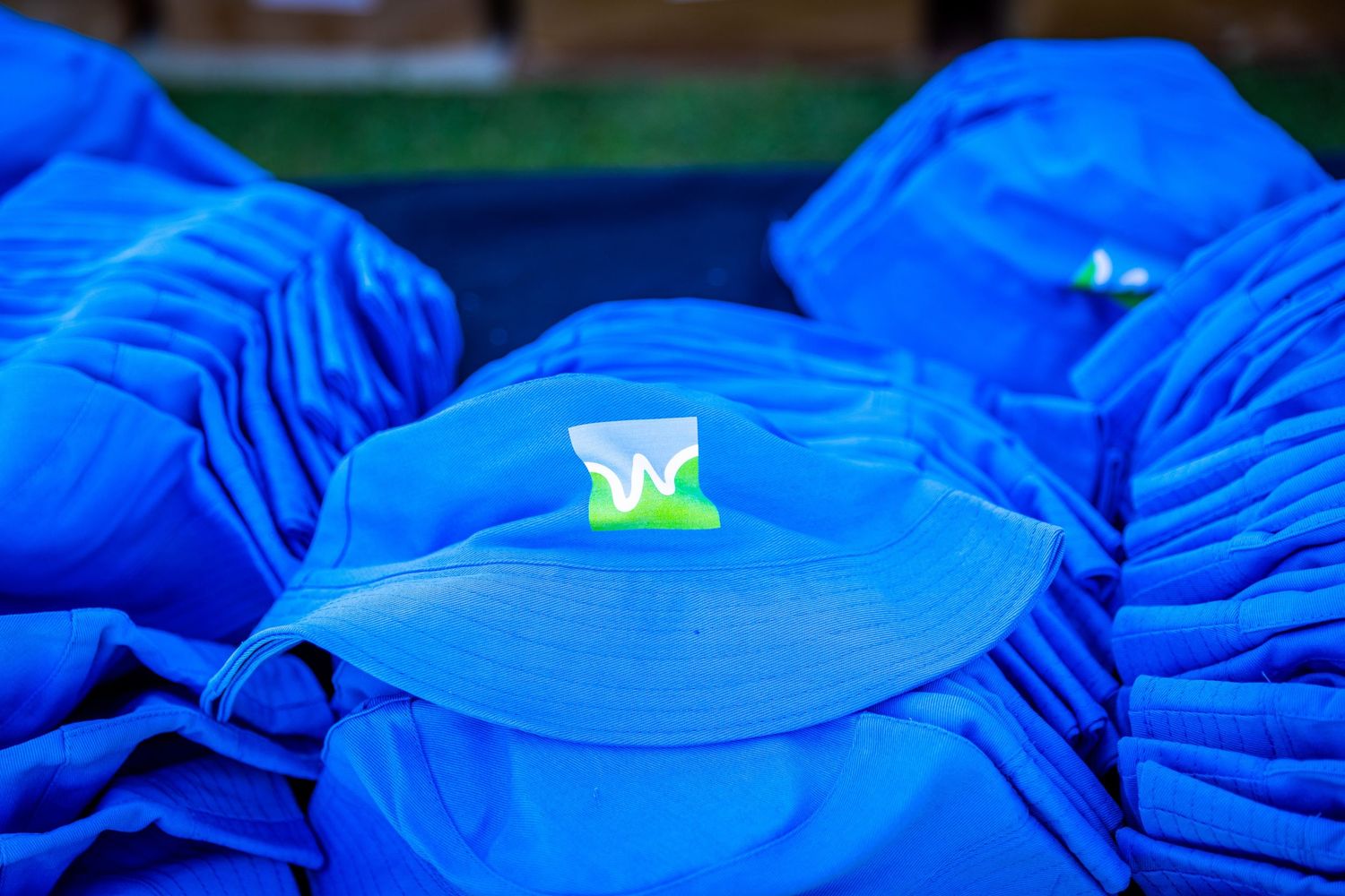 Close-up of folded blue branded t-shirts displayed at promotional event.