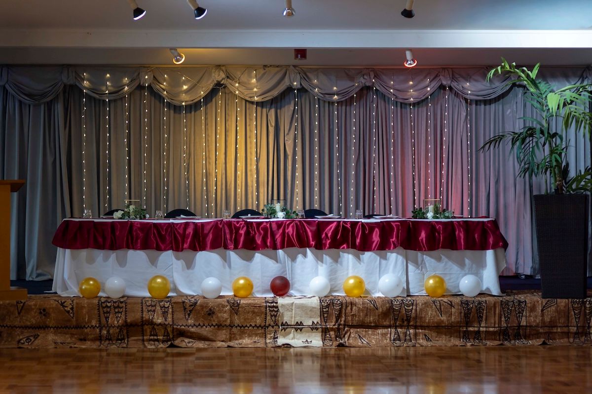 Empty stage with red curtains and rows of folding chairs set up for a performance or event.