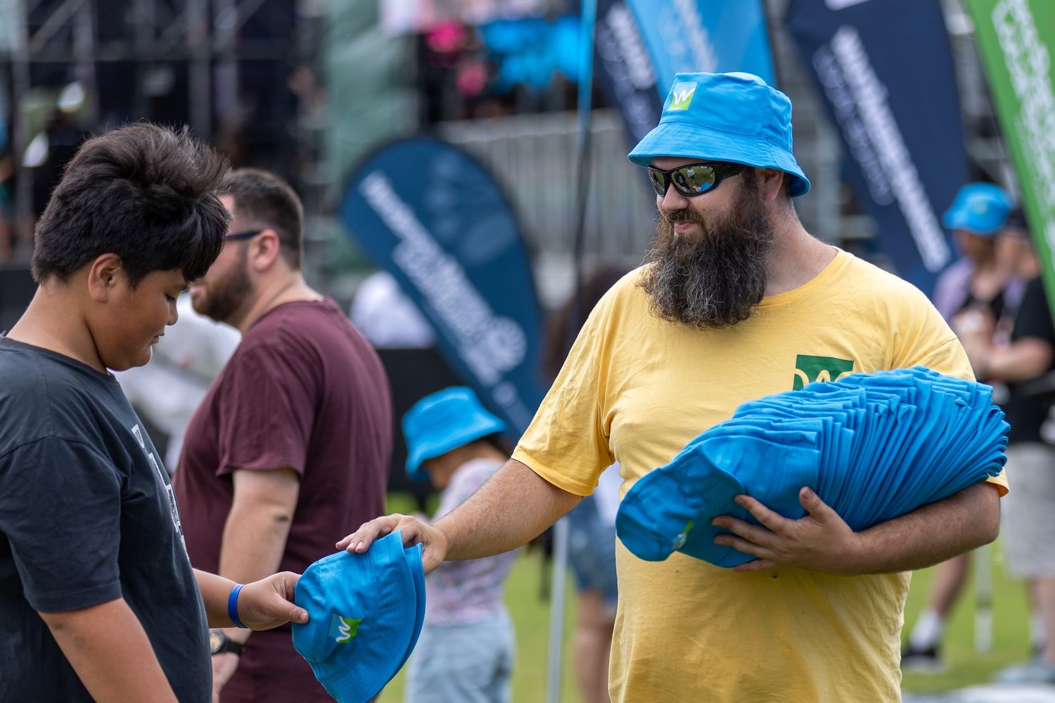 People in colorful t-shirts gathering at outdoor summer festival.