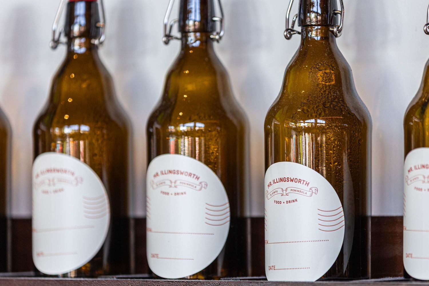 Row of brown glass bottles with white labels lined up on a shelf showing a repeating pattern.