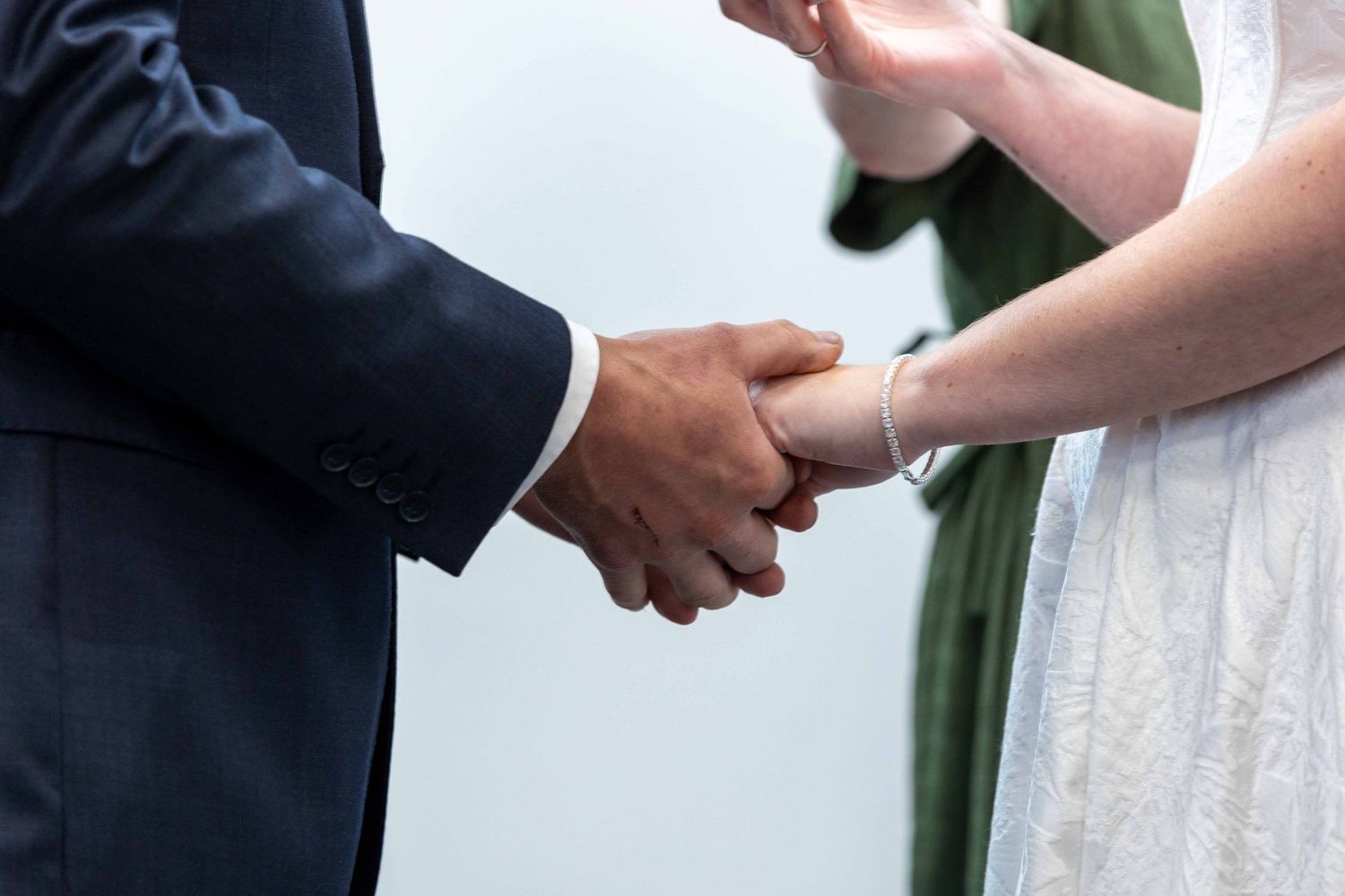 Close-up of hands during a wedding ceremony exchange.