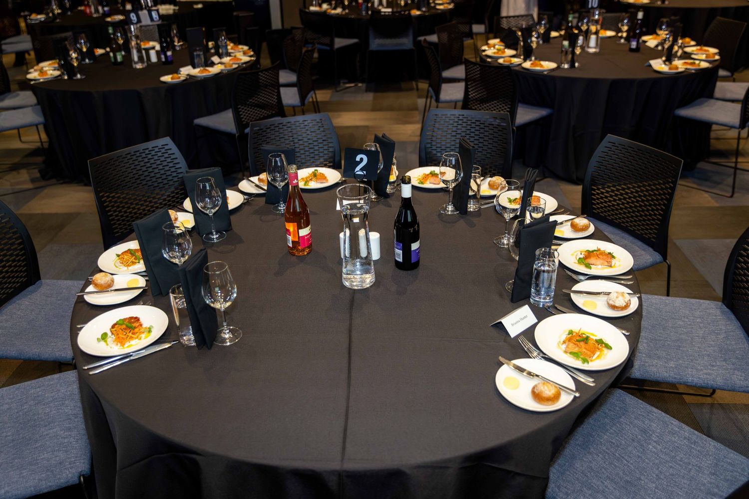 Elegant table setting at a formal dinner event with place settings and centerpieces.
