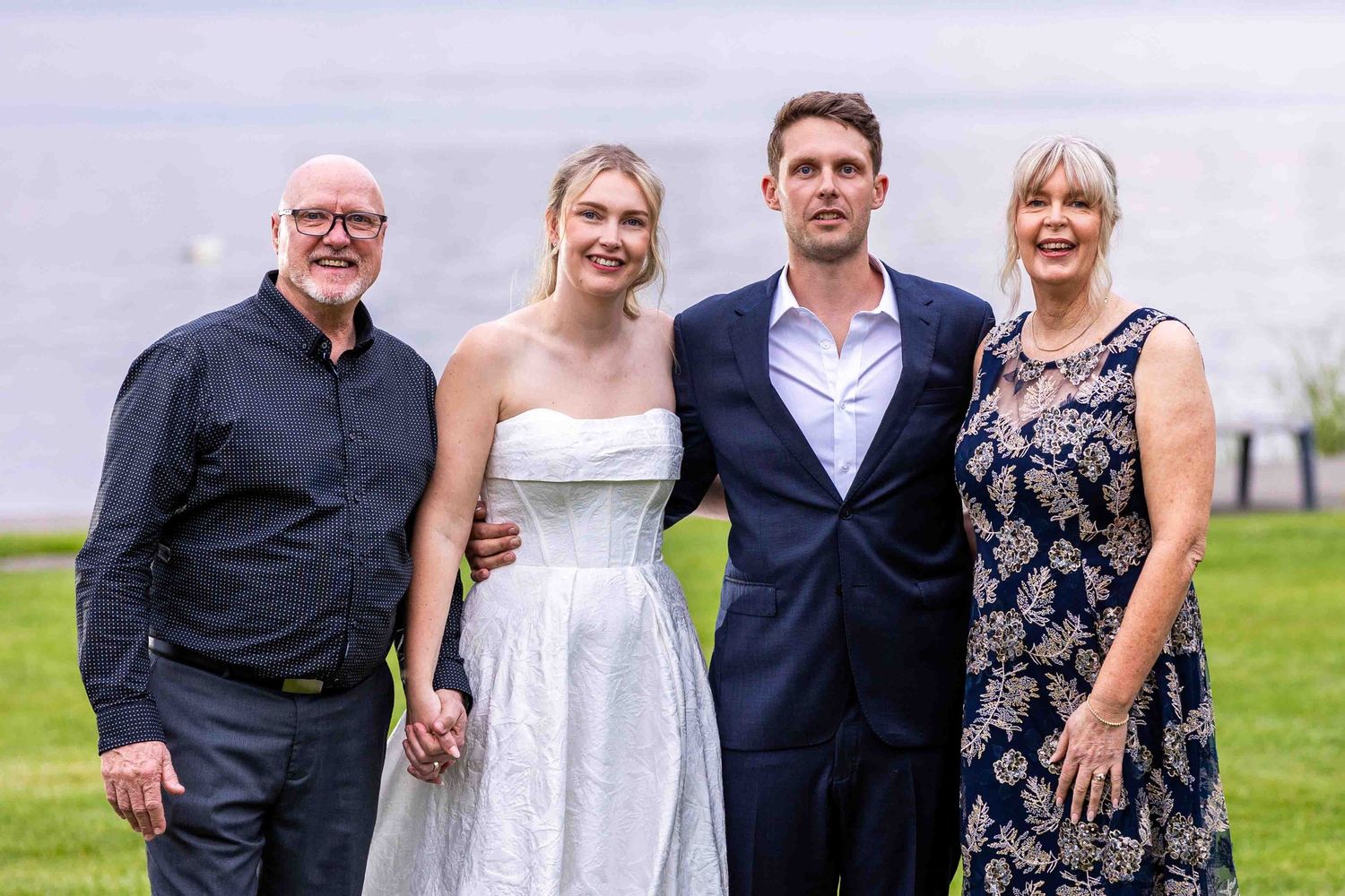 Family members gather for formal wedding portraits outdoors.